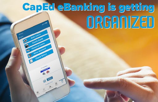 A cell phone help in one hand showing the screen with CapEd Mobile Banking options on it.