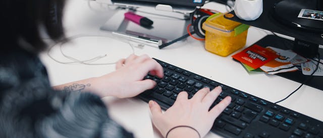 Woman typing on a keyboard at her desk