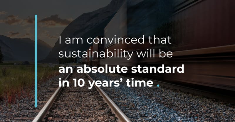 Blurred train on tracks in mountains. Text: "Sustainability will be an absolute standard in 10 years."