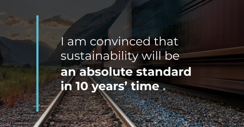 Blurred train on tracks in mountains. Text: "Sustainability will be an absolute standard in 10 years."