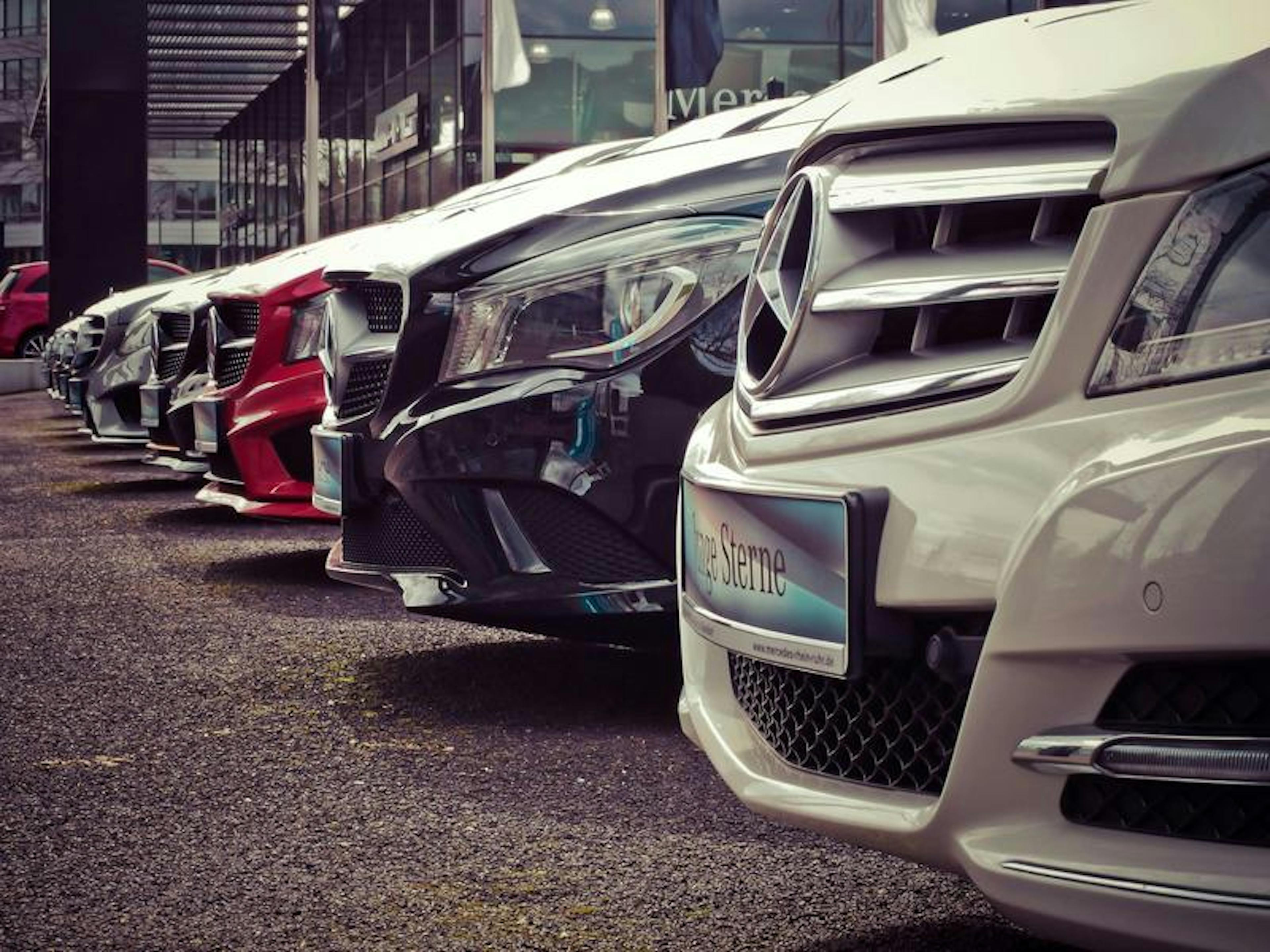 Cars neatly parked at a dealership; license plate "Junge Sterne" of mercedes-benz.