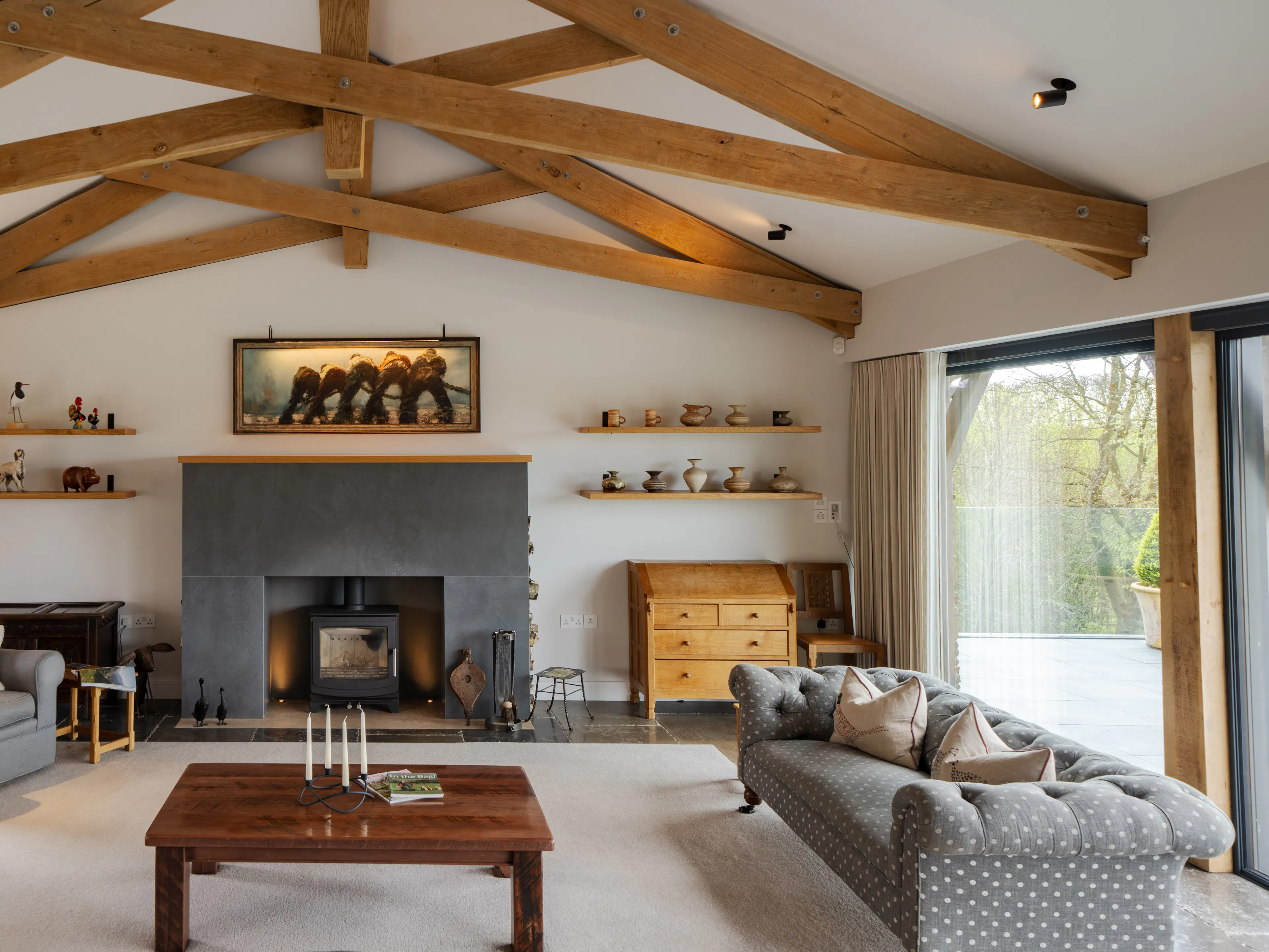 An oak framed living room with feature scissor trusses and a log burner