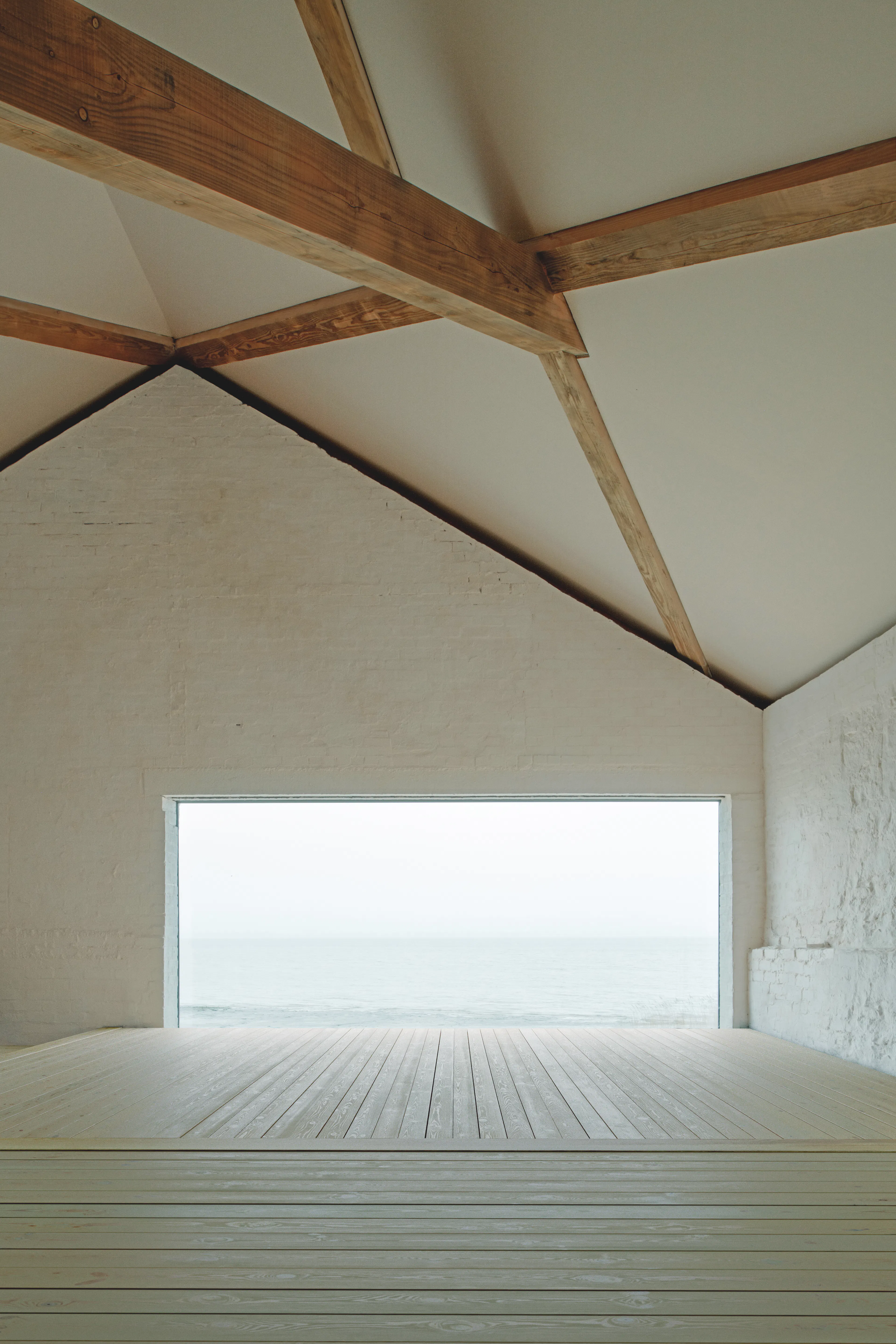 Interior of a riverside boathouse with a complex structural timber frame