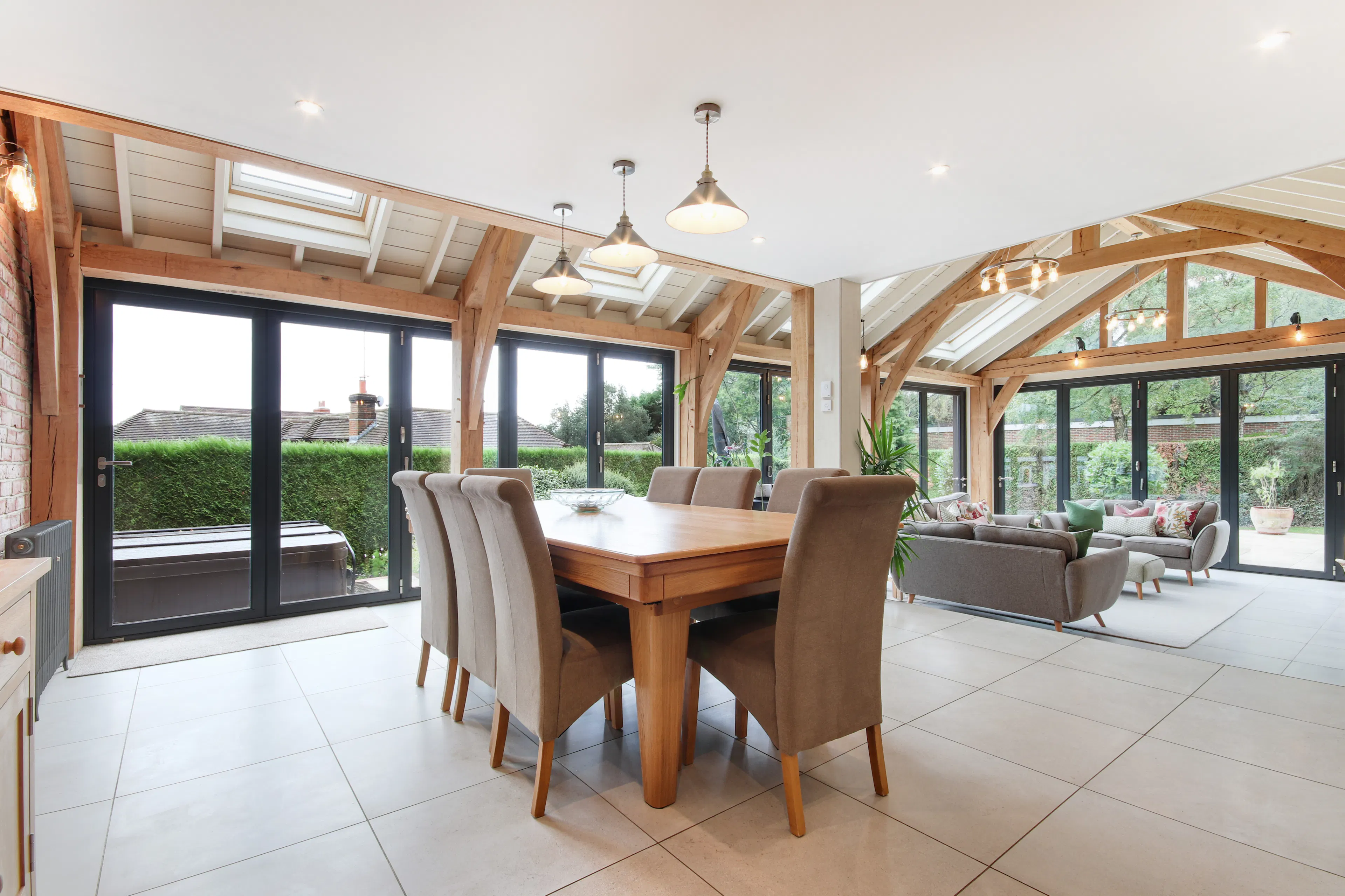 A modern oak framed extension encompassing an open plan family room and dining area with integrated glazing and roof lights providing lots of natural light.