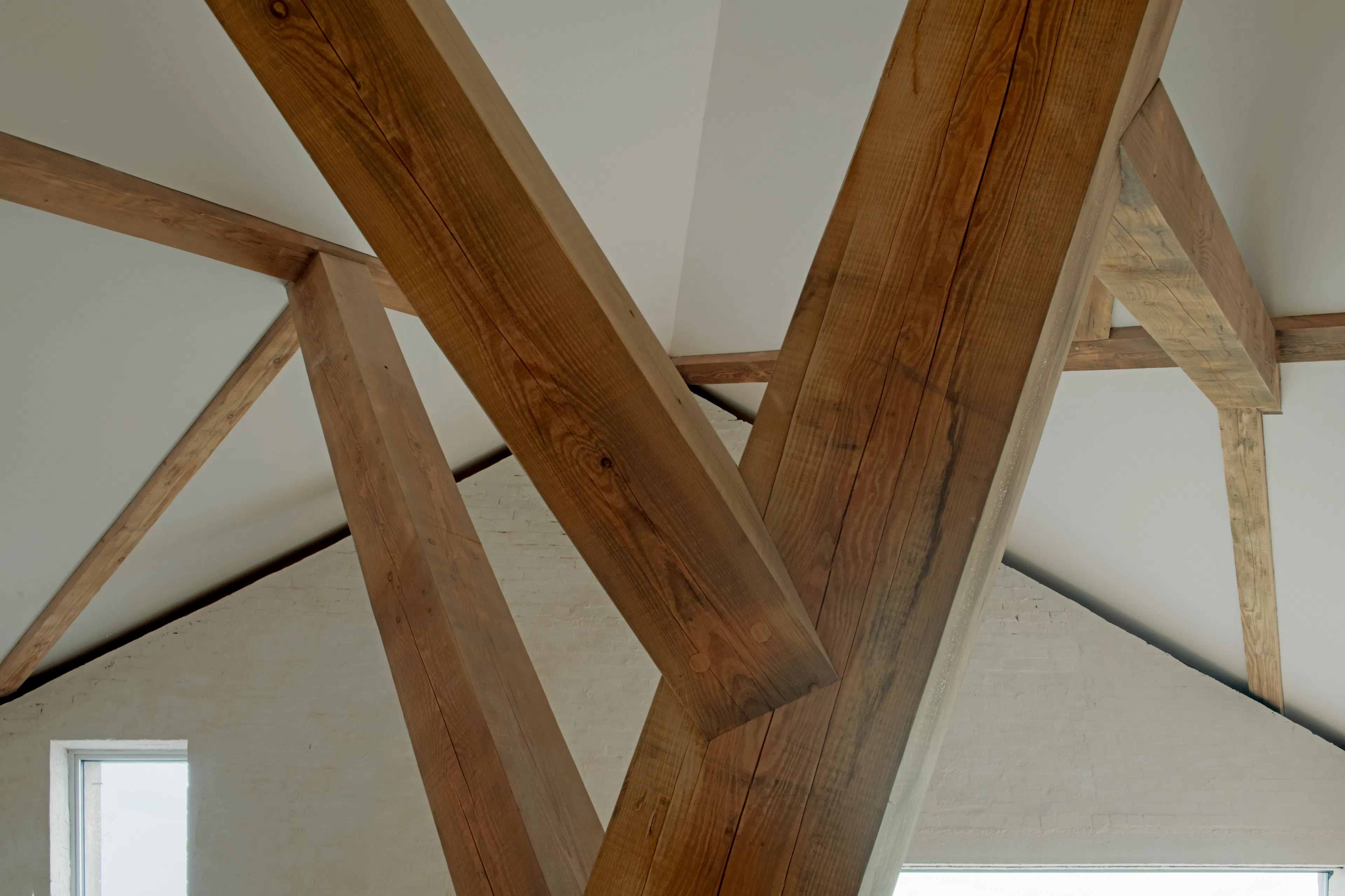 Interior of a riverside boathouse with a complex structural timber frame
