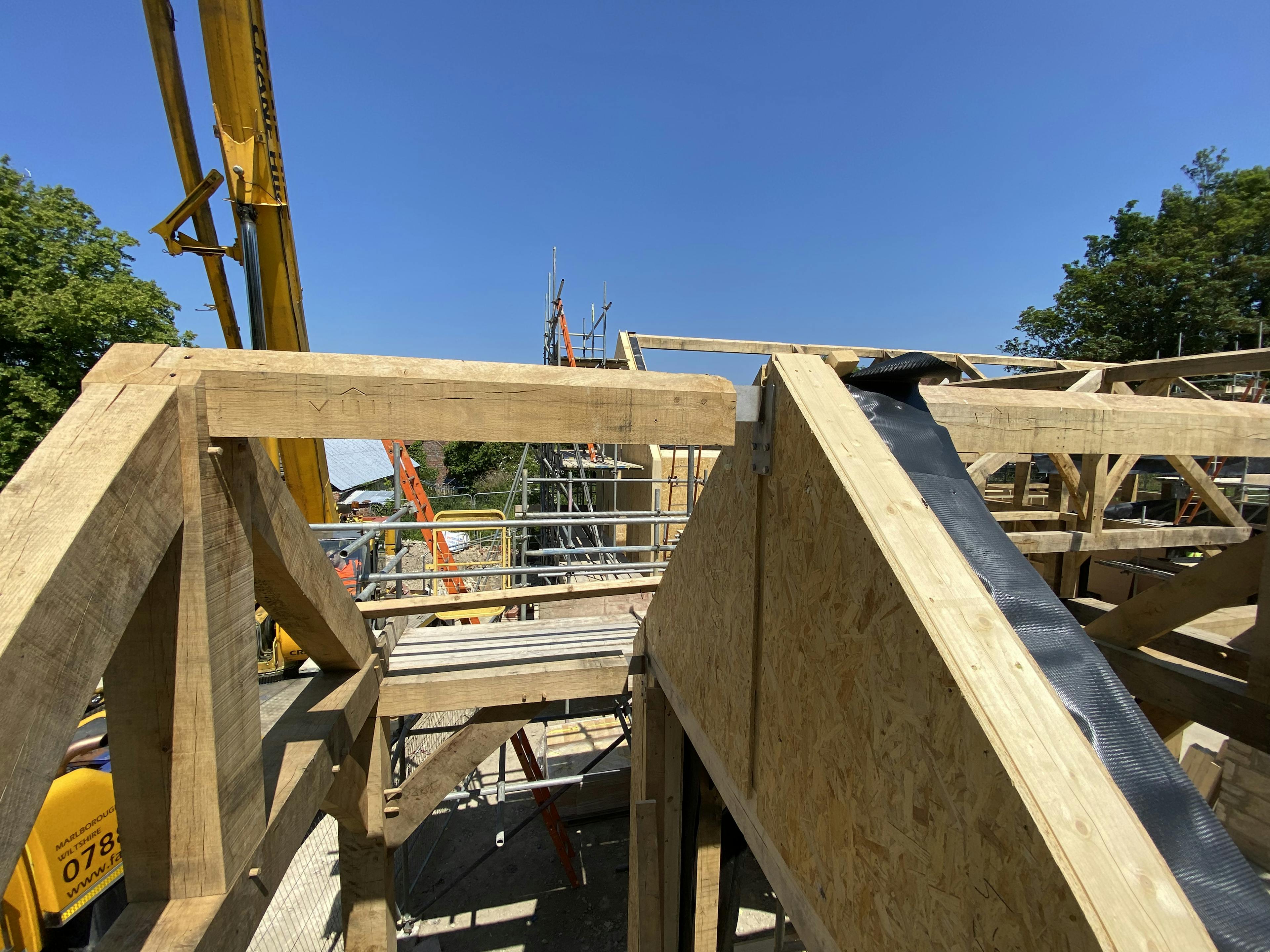 An oak frame home during installation with sips panels 