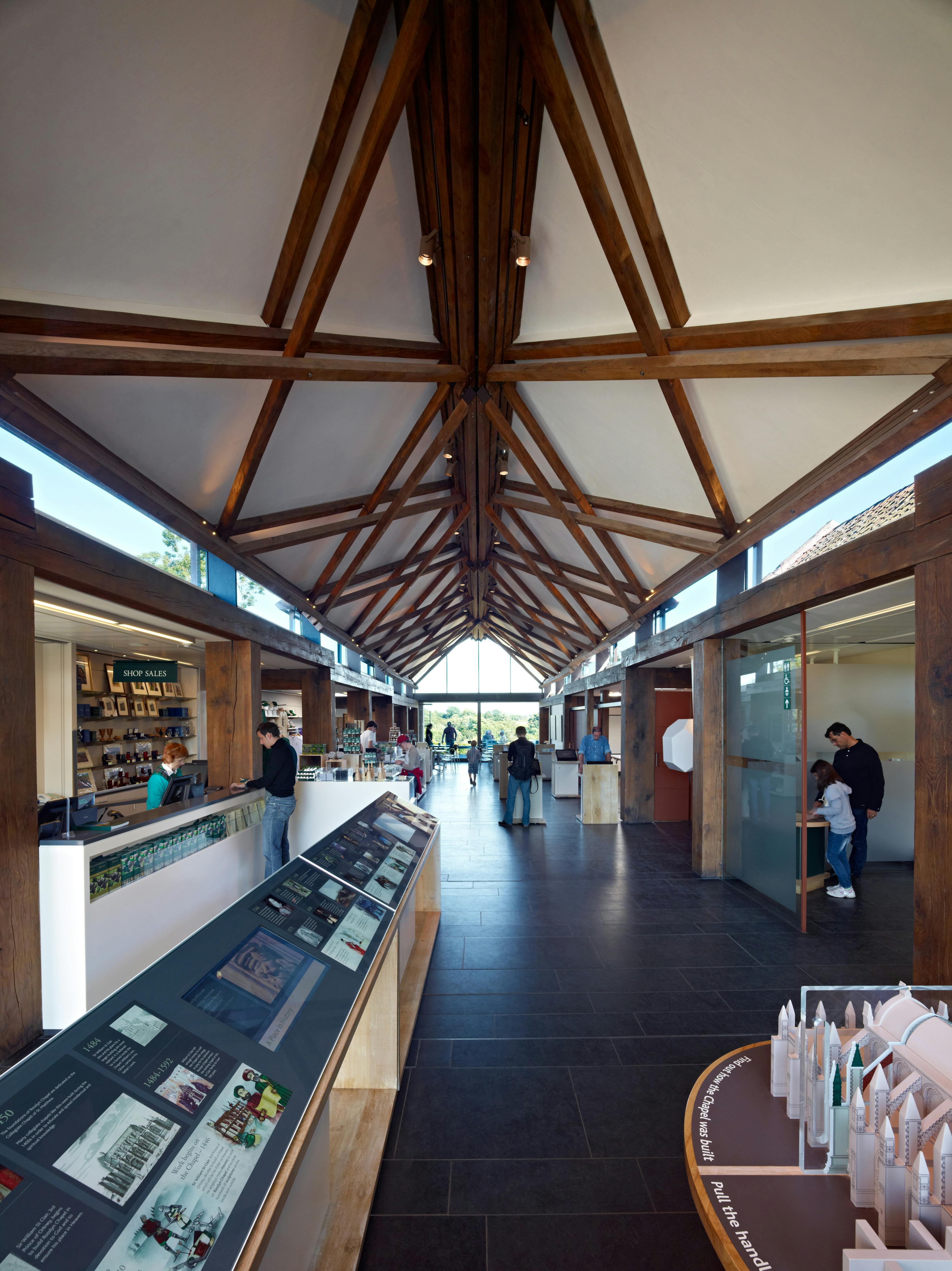 A visitors centre at a chapel in Scotland with scissor braced slender timbers create a criss-crossed timber framed roof structure