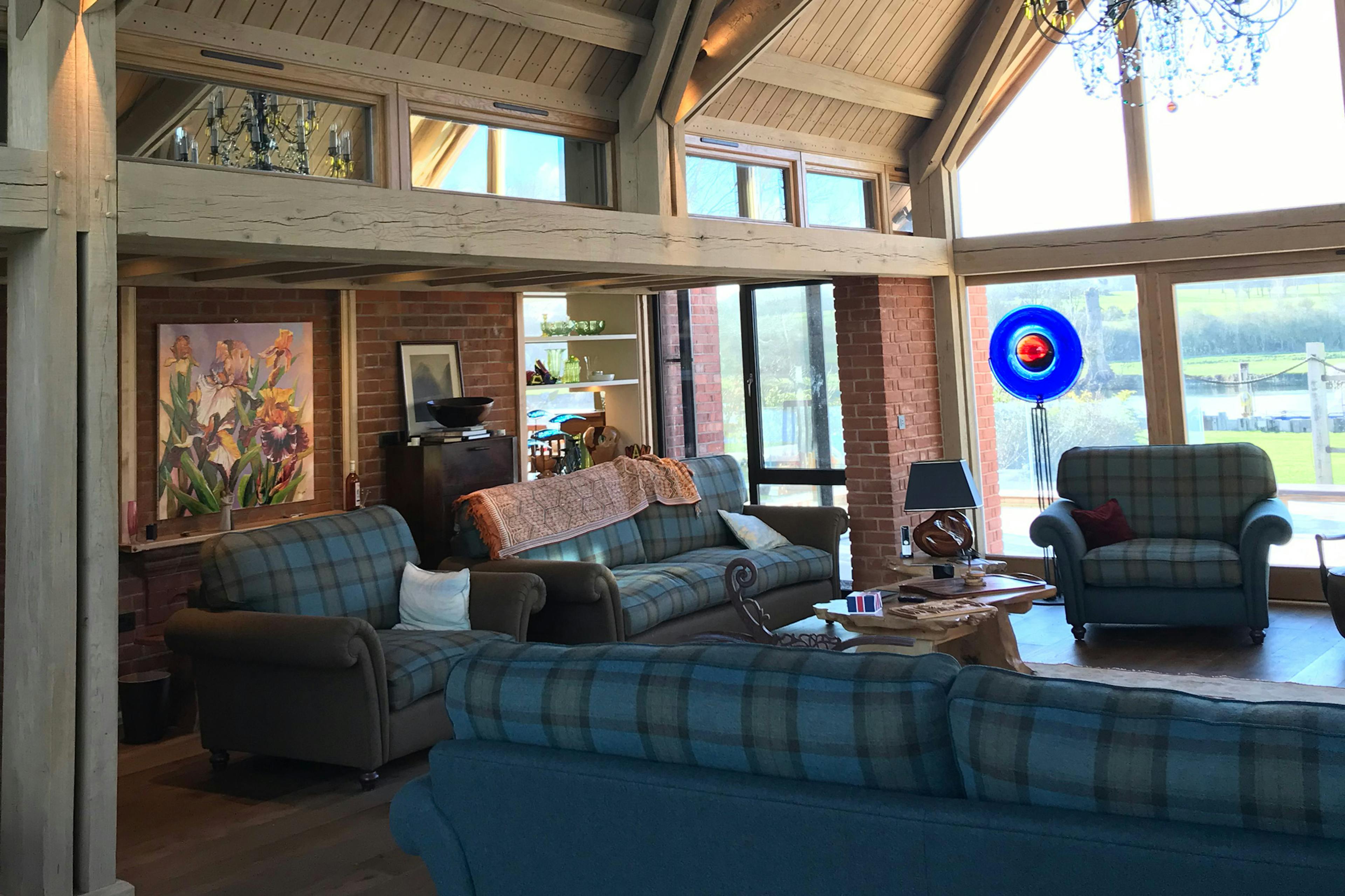The sitting room of an oak framed extension with sofas and armchairs