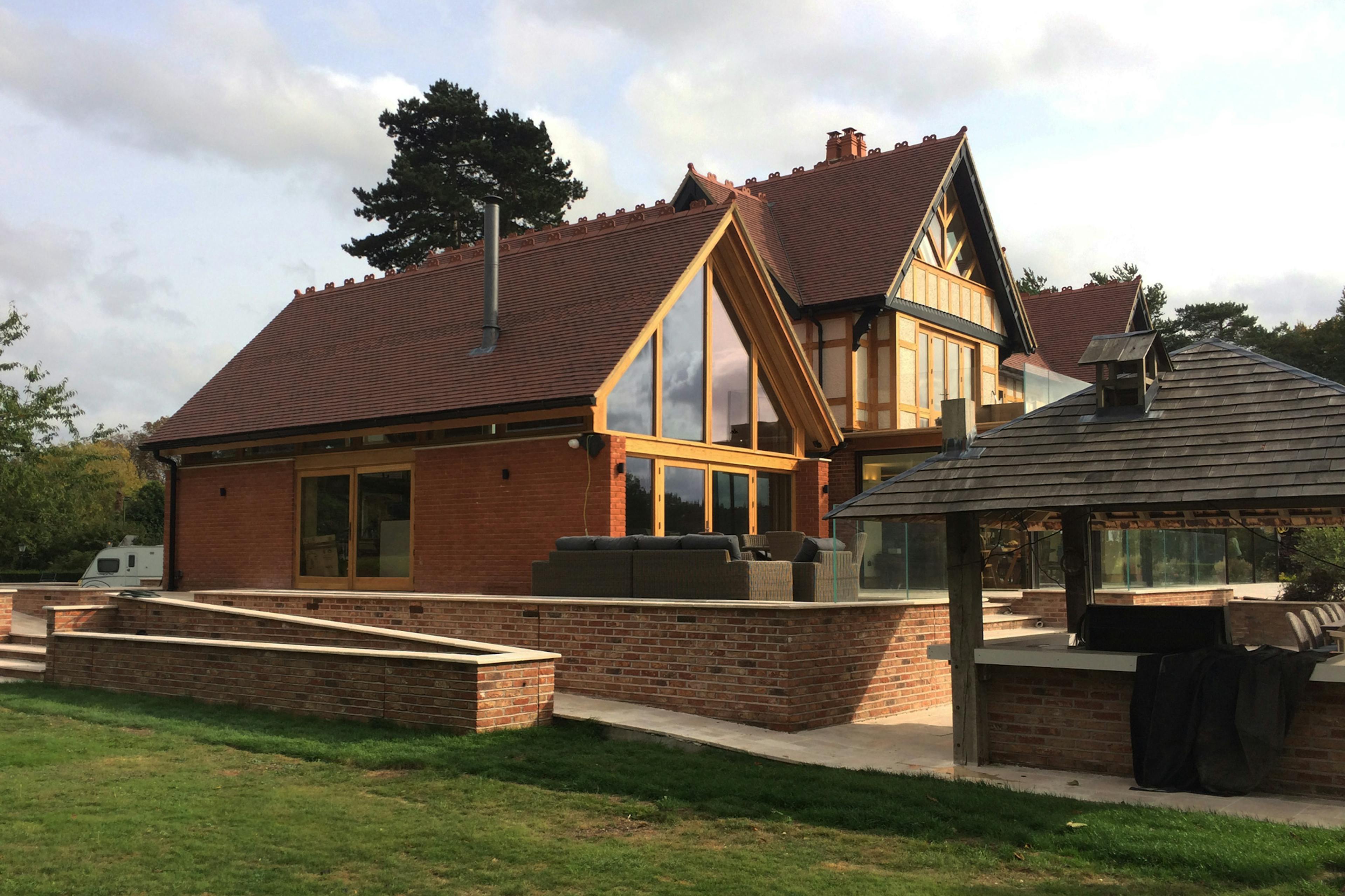 An oak framed extension with a glazed gable end to an arts and craft style house