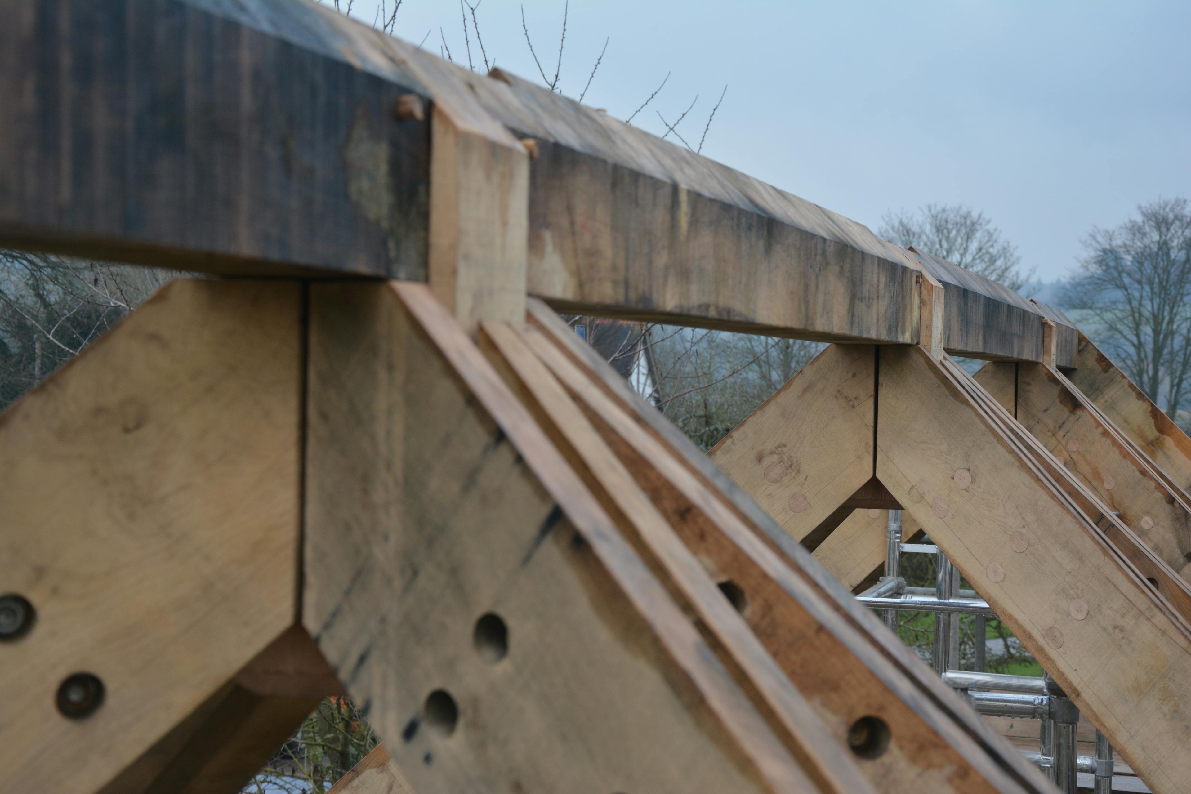 An oak frame with steel connections being installed