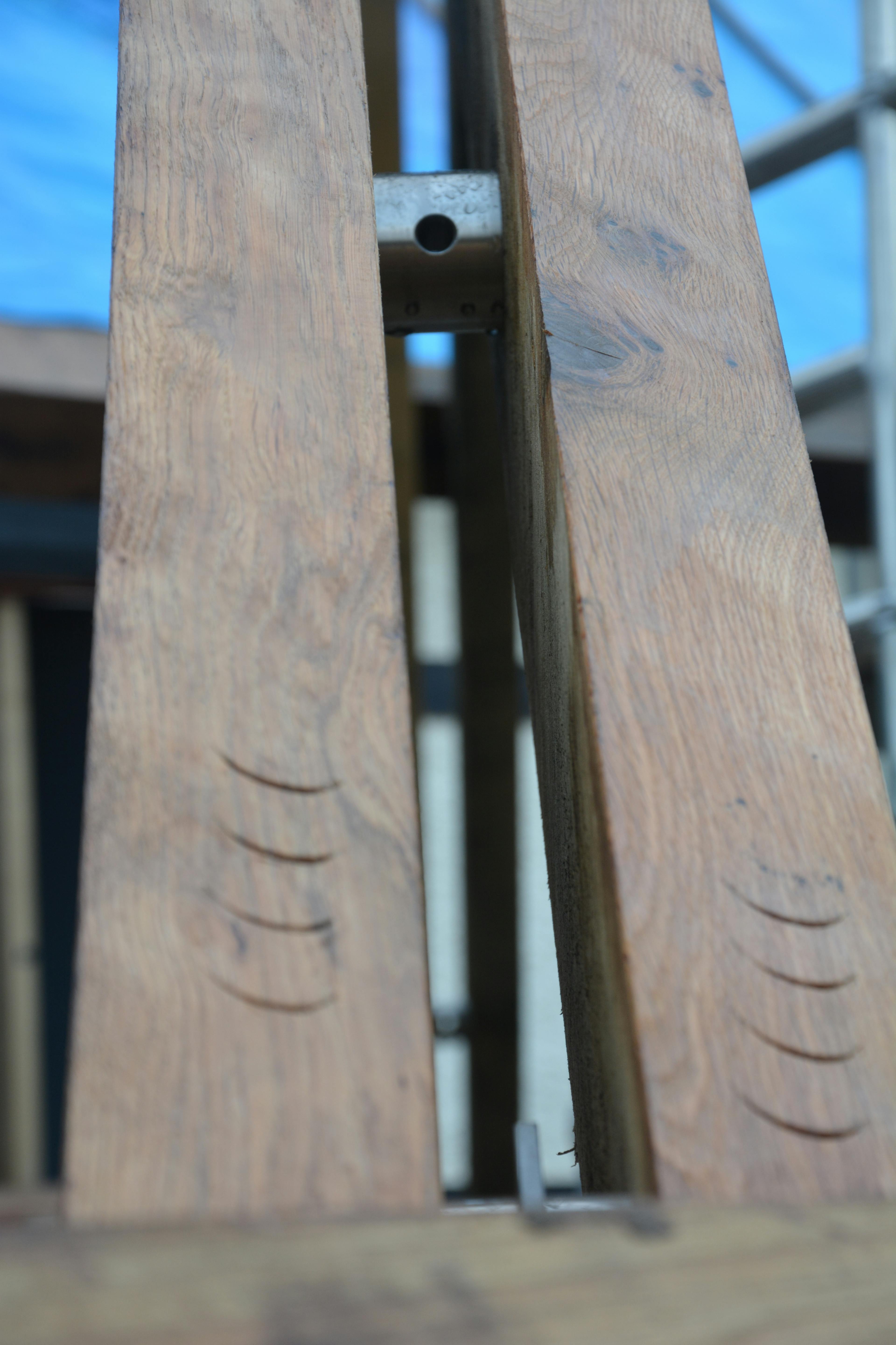 An oak frame with steel connections and carpenter's marks during installation