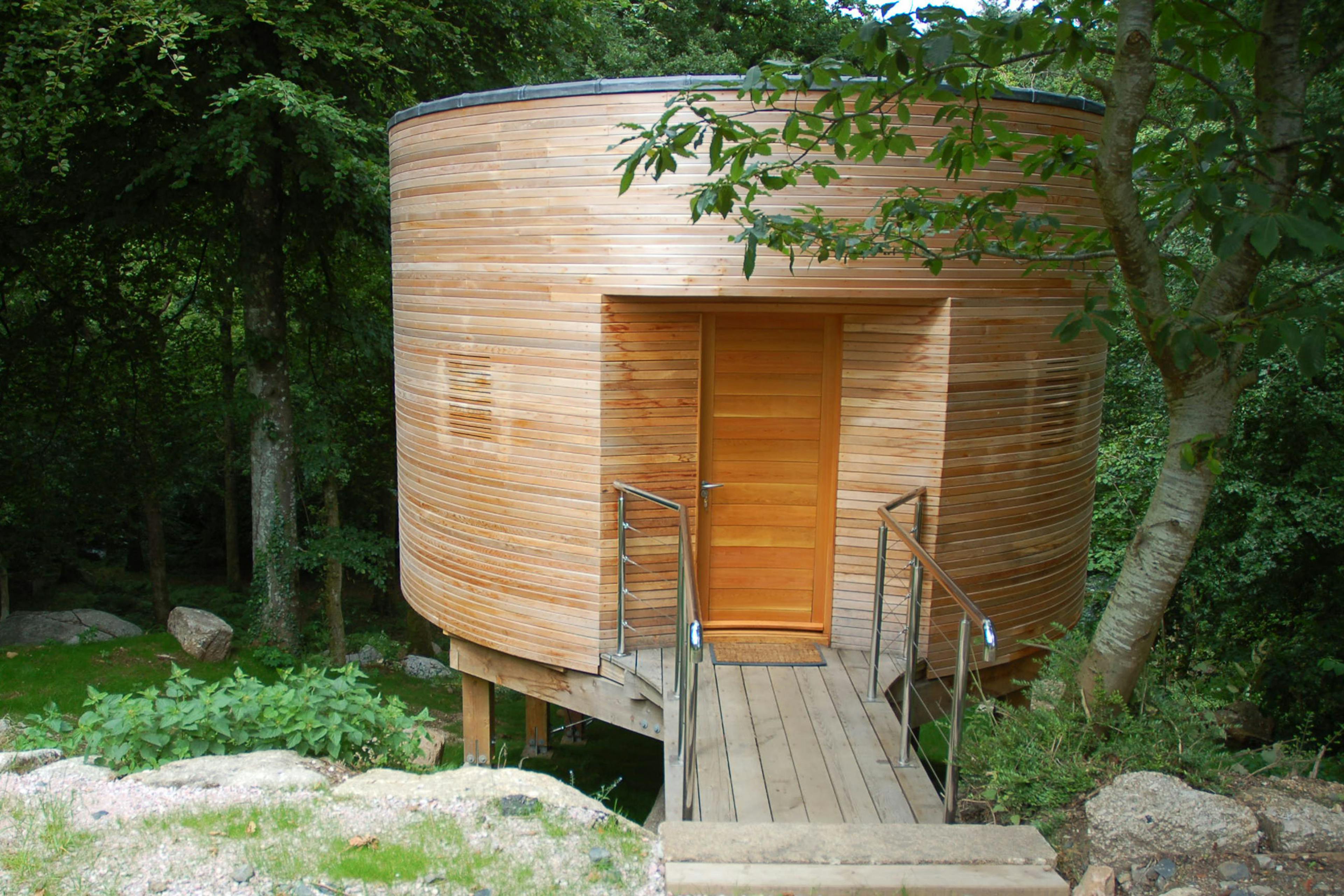 A timber clad Douglas fir framed cabin with a bridge to the entrance door