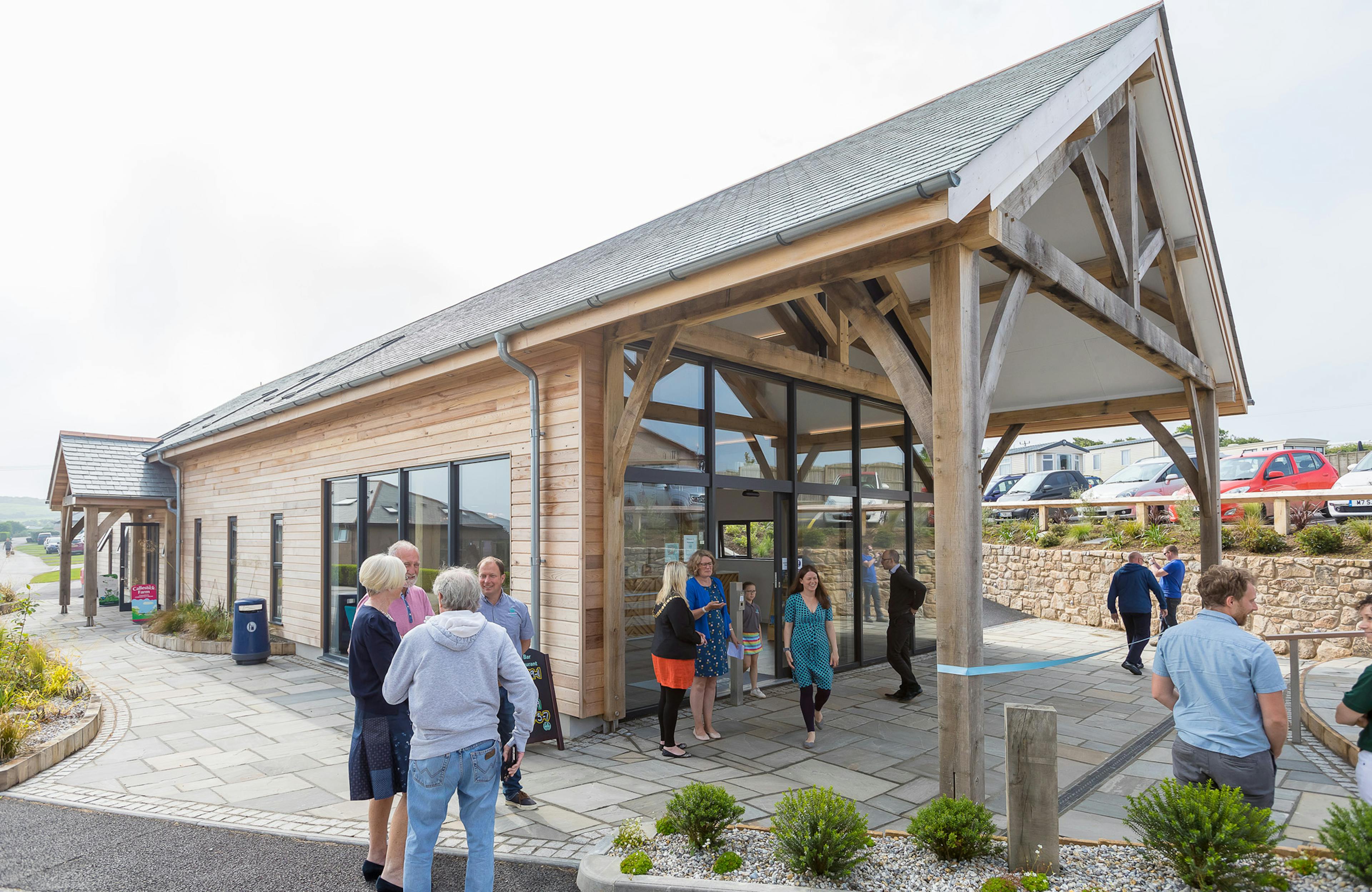 Guests outside an oak framed entrance porch for a reception area at a caravan park 