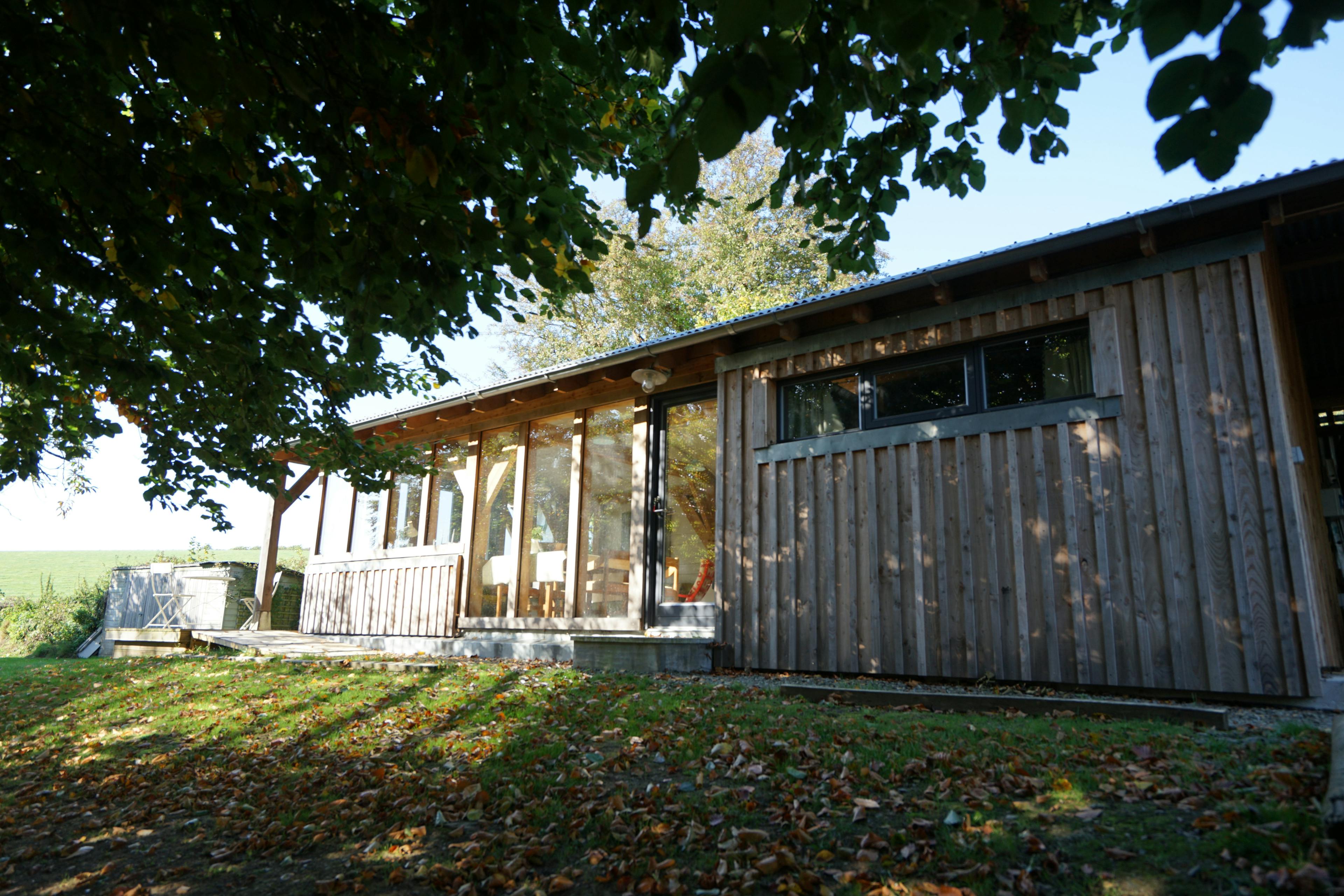 The side of an oak framed cabin with traditional direct glazing