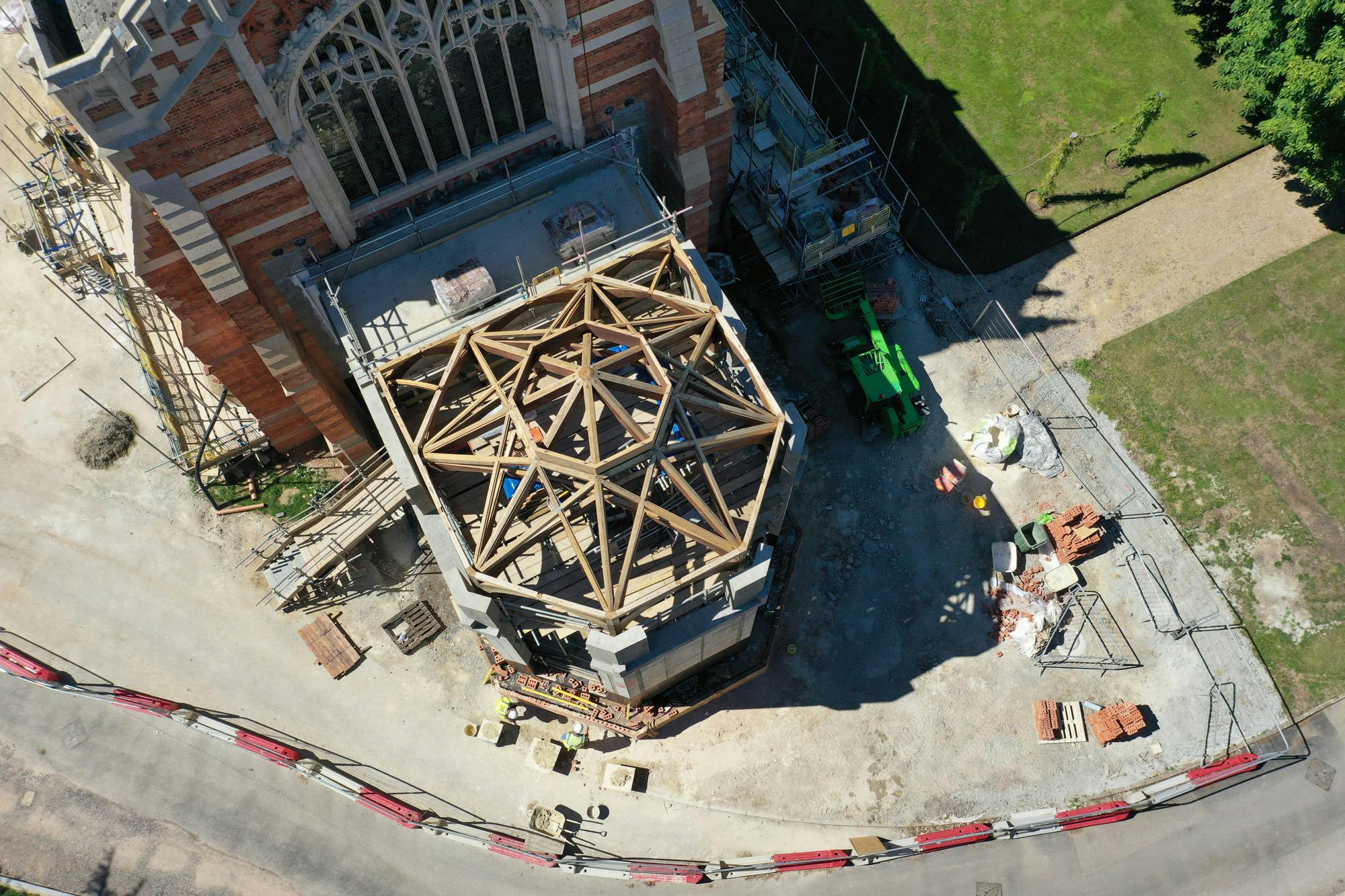 An aerial view of an extension to a 19th century chapel with an octagonal oak framed roof structure during construction