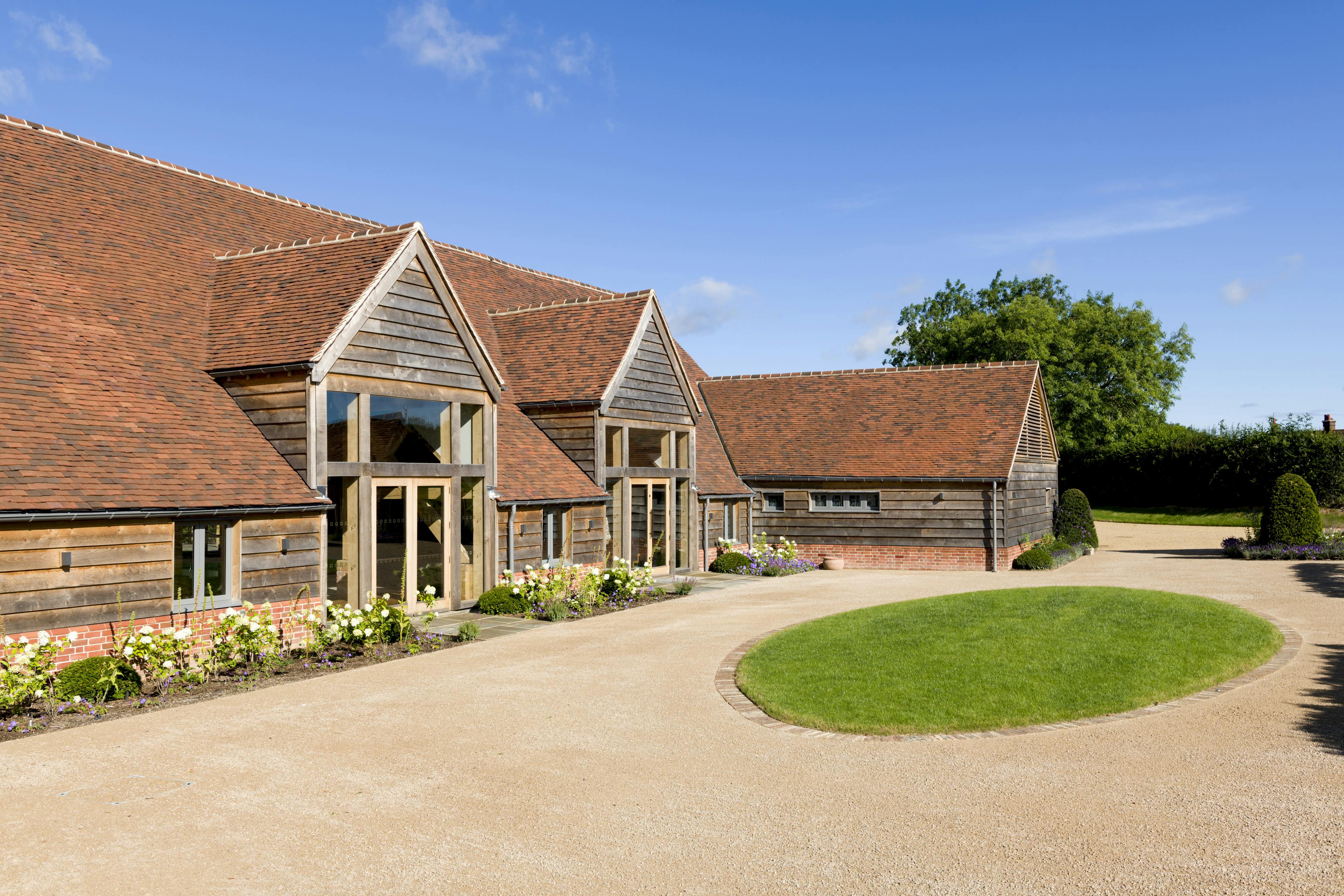A red tiled oak framed wedding venue with landscaped gardens