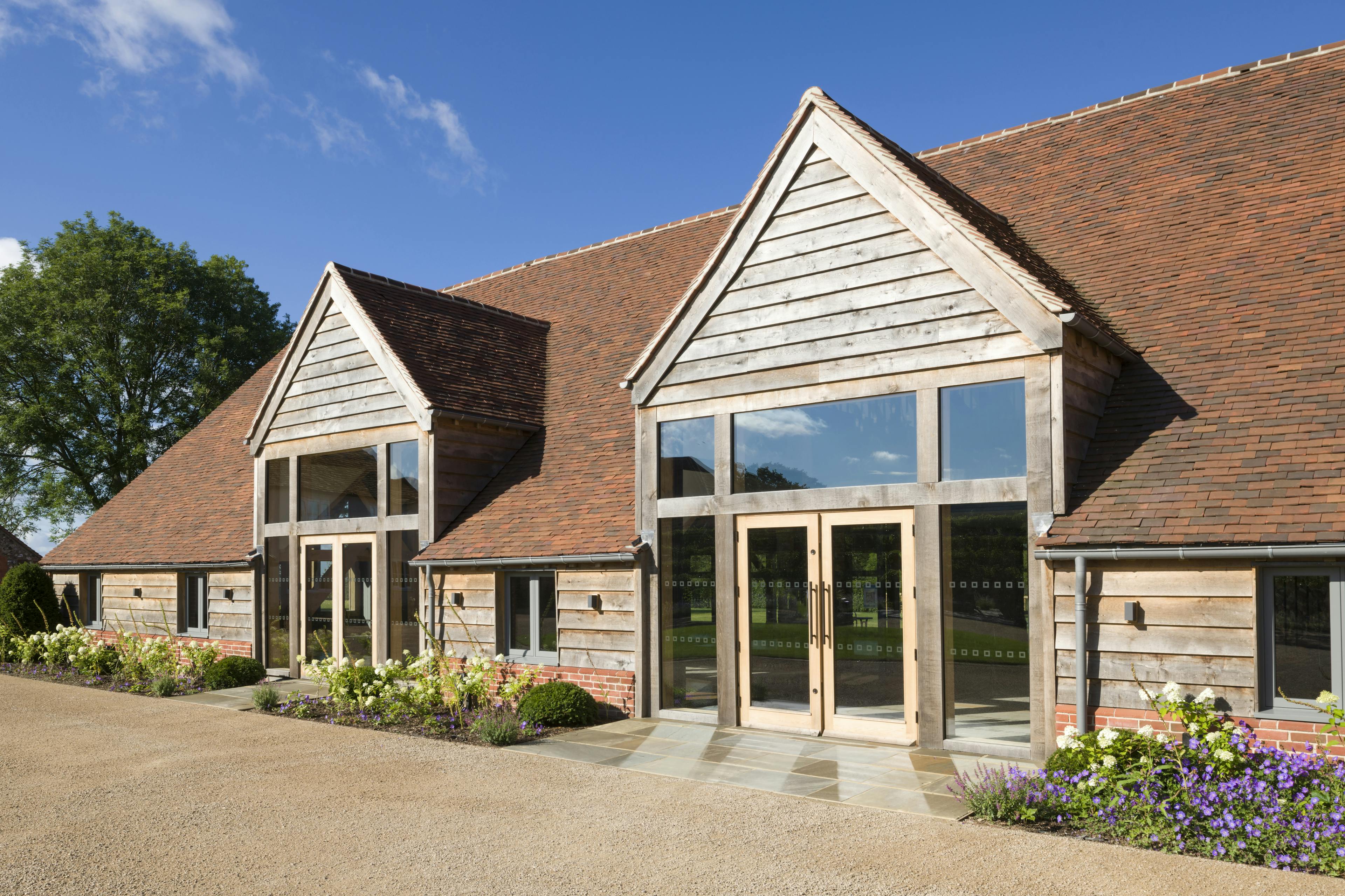 A red tiled oak framed wedding venue with landscaped gardens