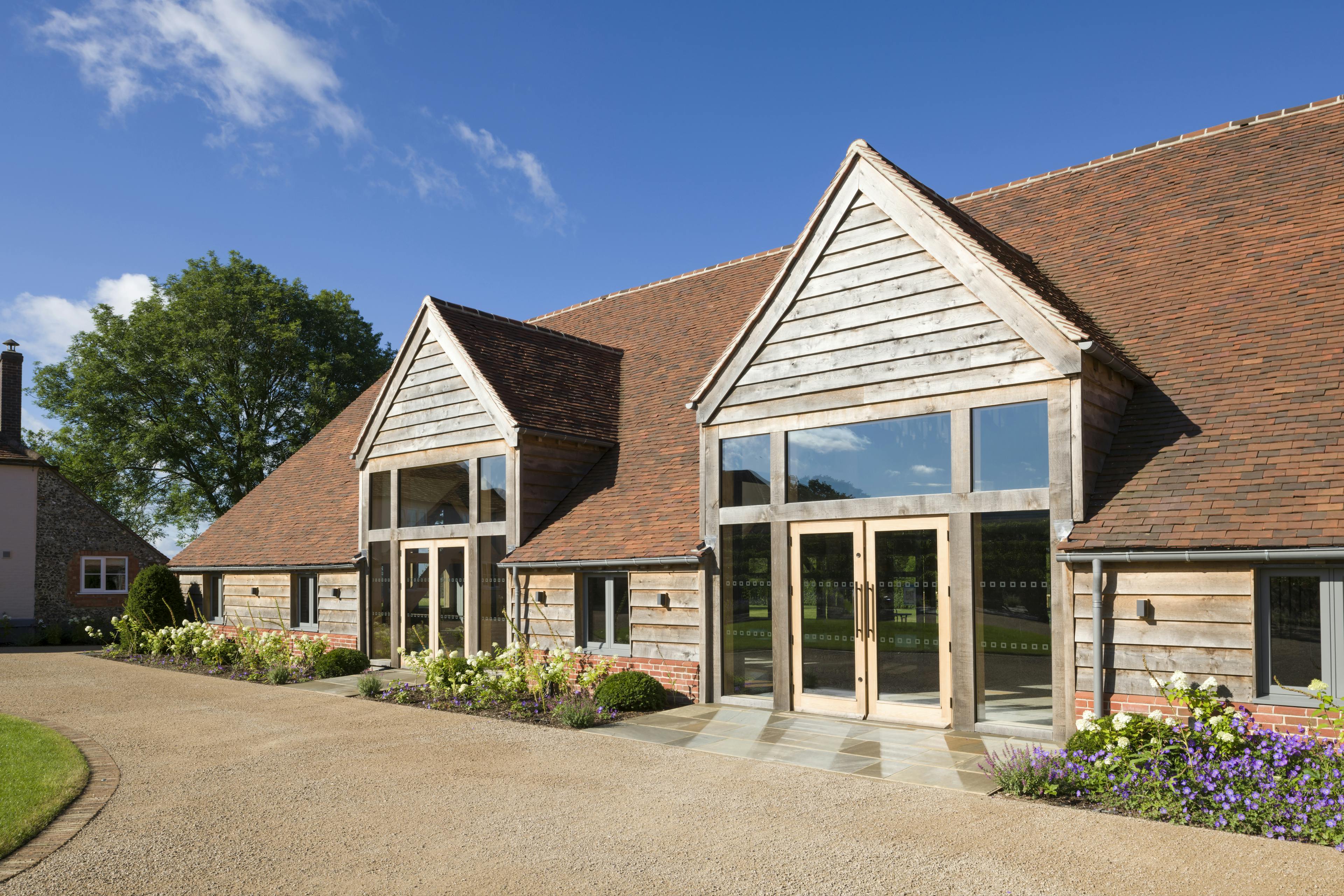 A red tiled oak framed wedding venue with landscaped gardens