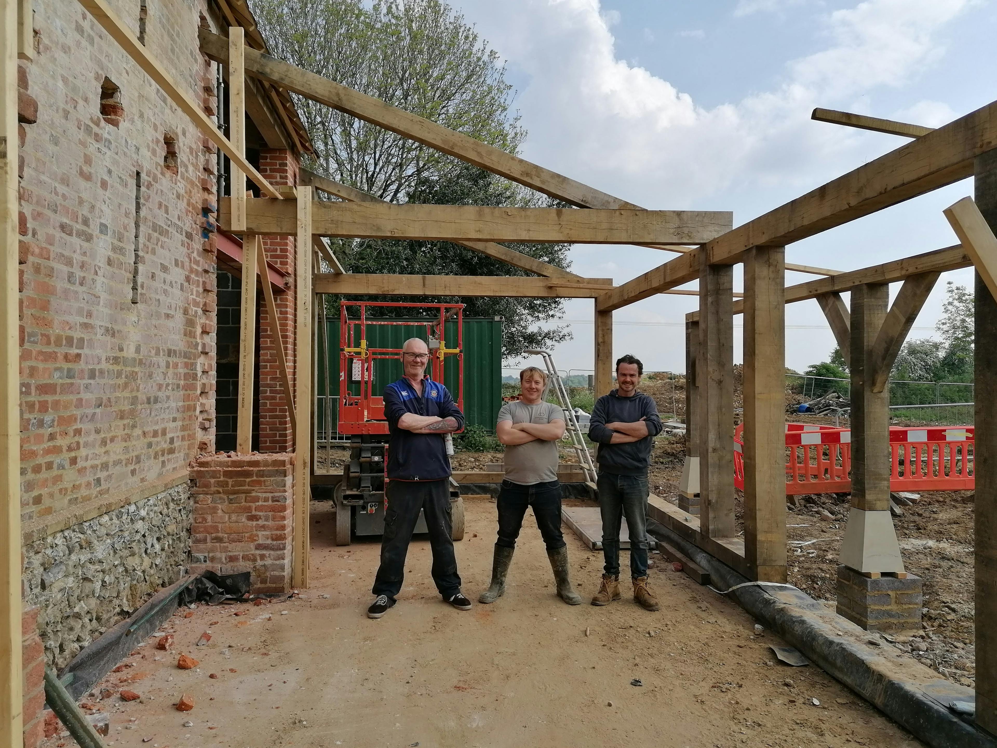 Carpenters on site of an oak framed wedding barn during restoration and installation 