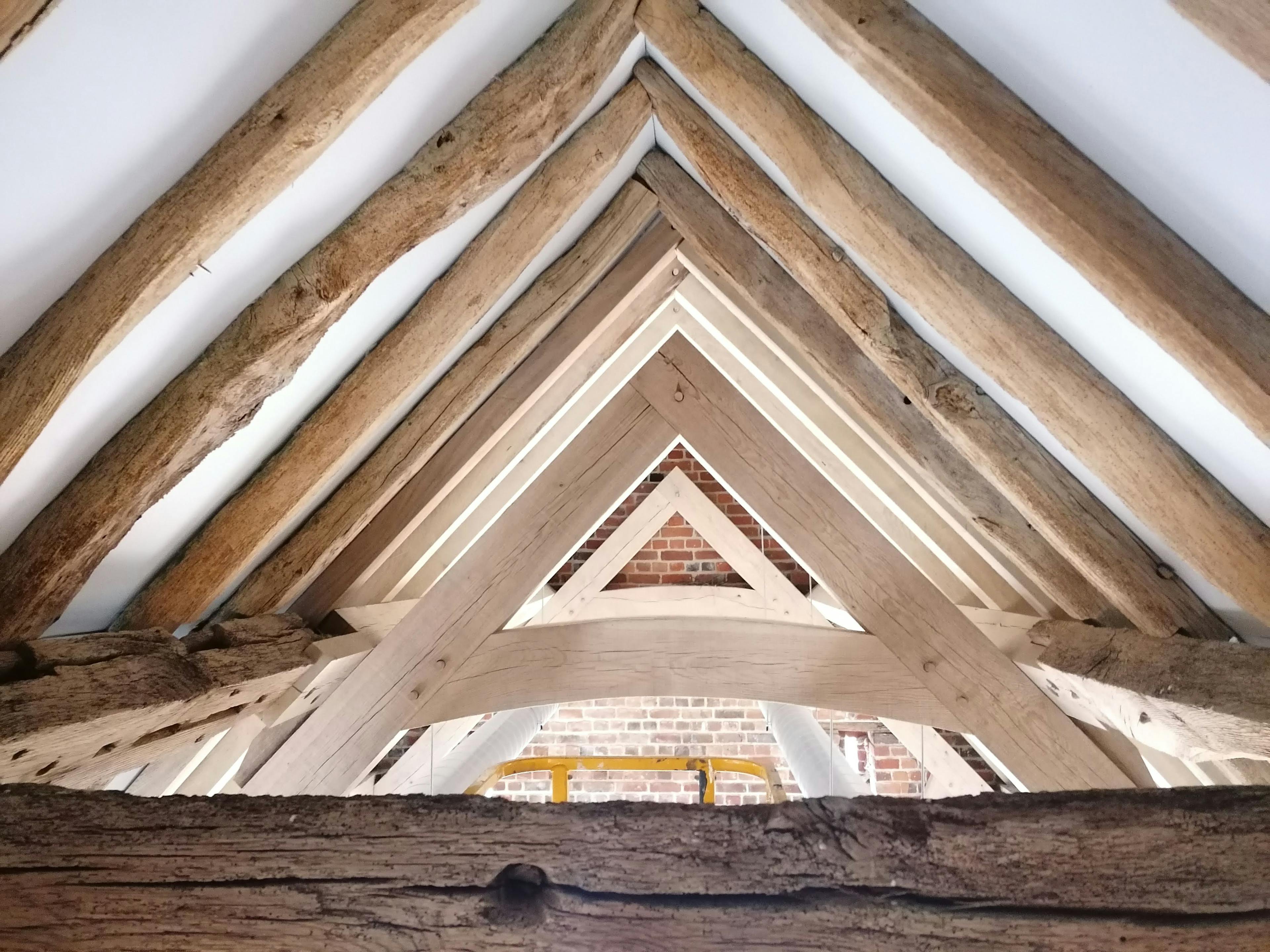 A new oak frame truss inserted under an old oak frame