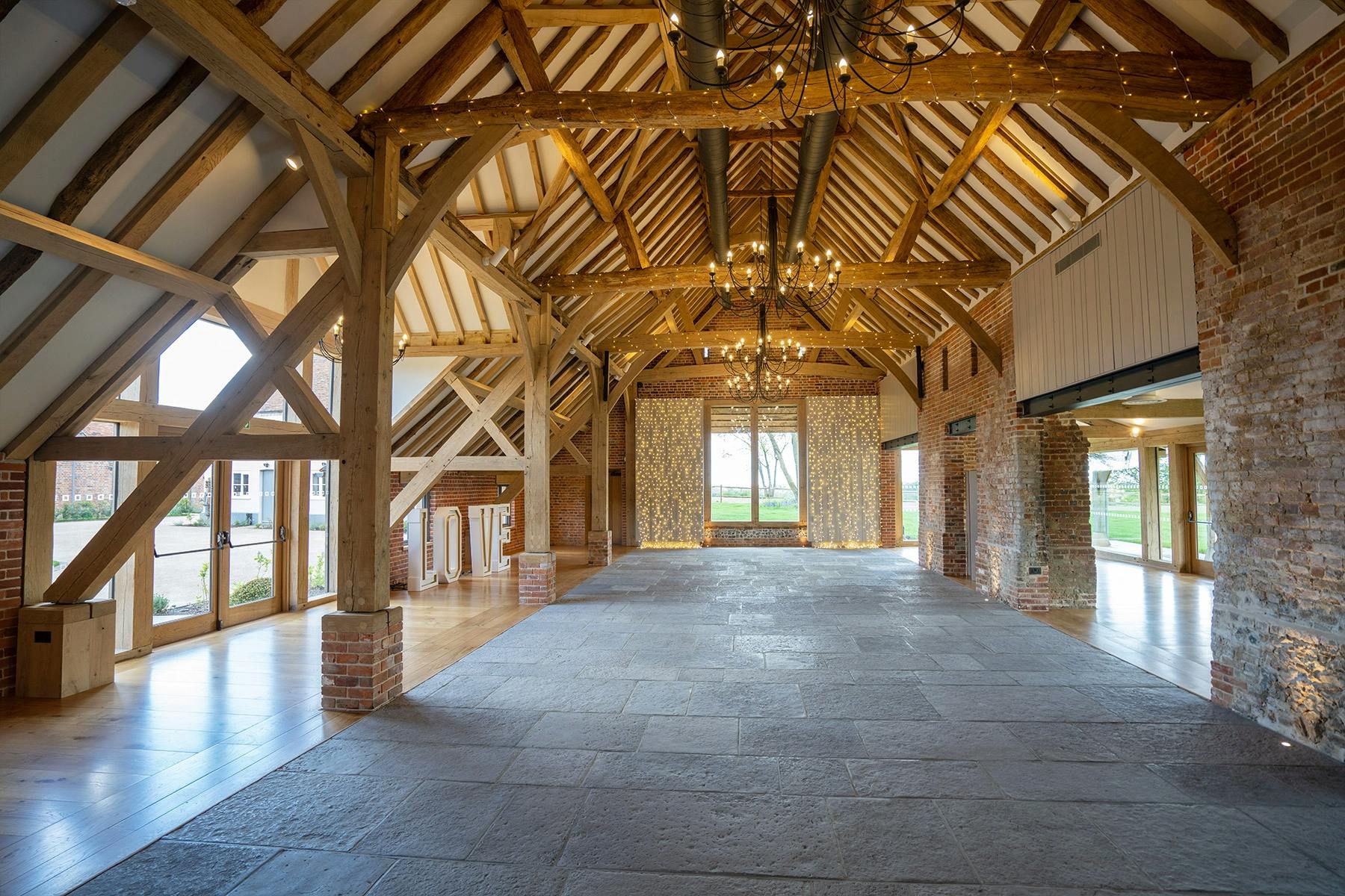 An oak framed wedding barn hall with a red brick wall