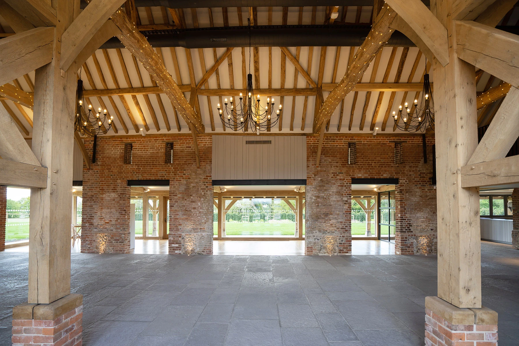 An oak framed wedding barn hall with oak posts on red brick post feet