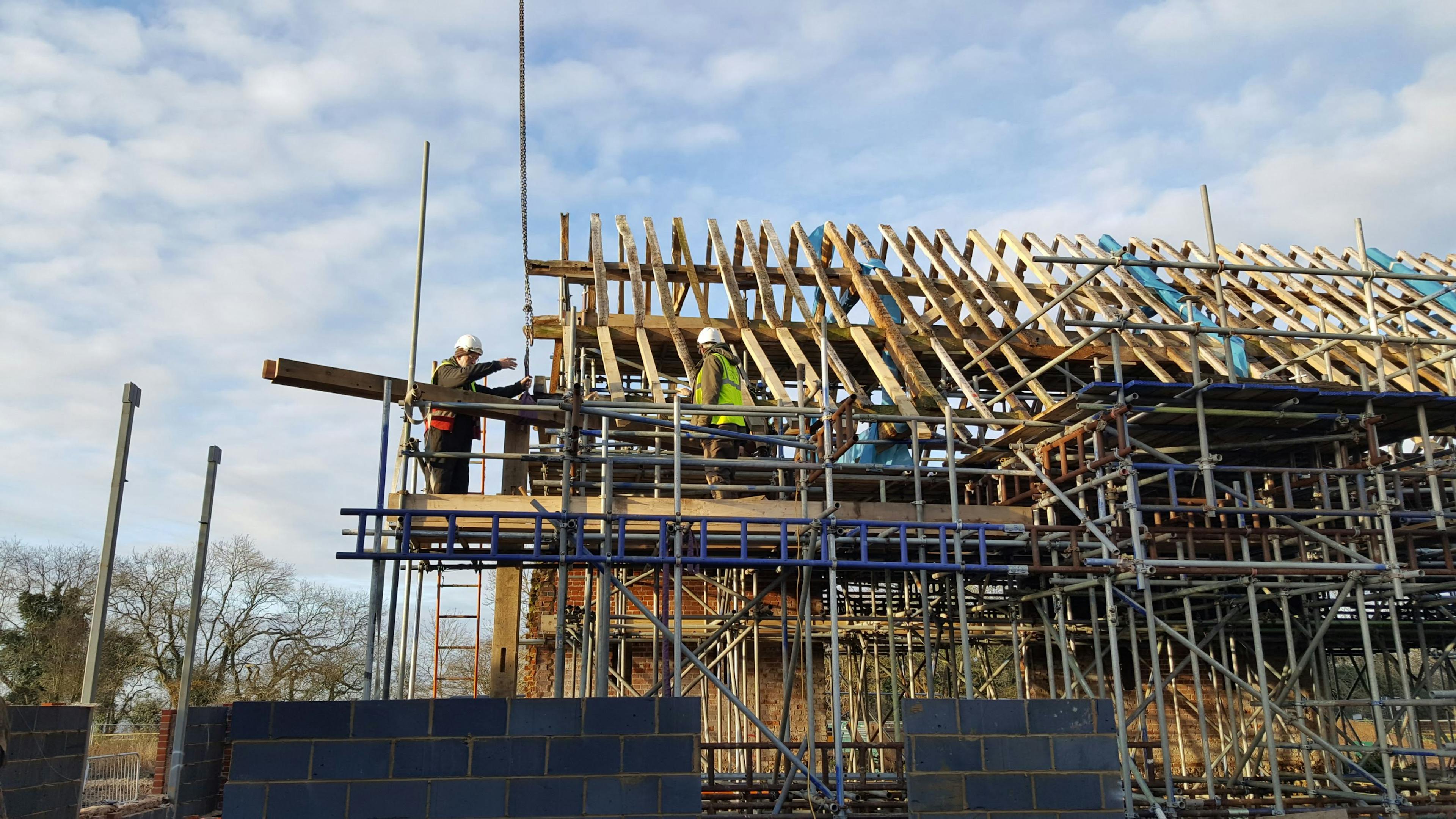 An oak framed wedding barn during restoration and installation with scaffolding