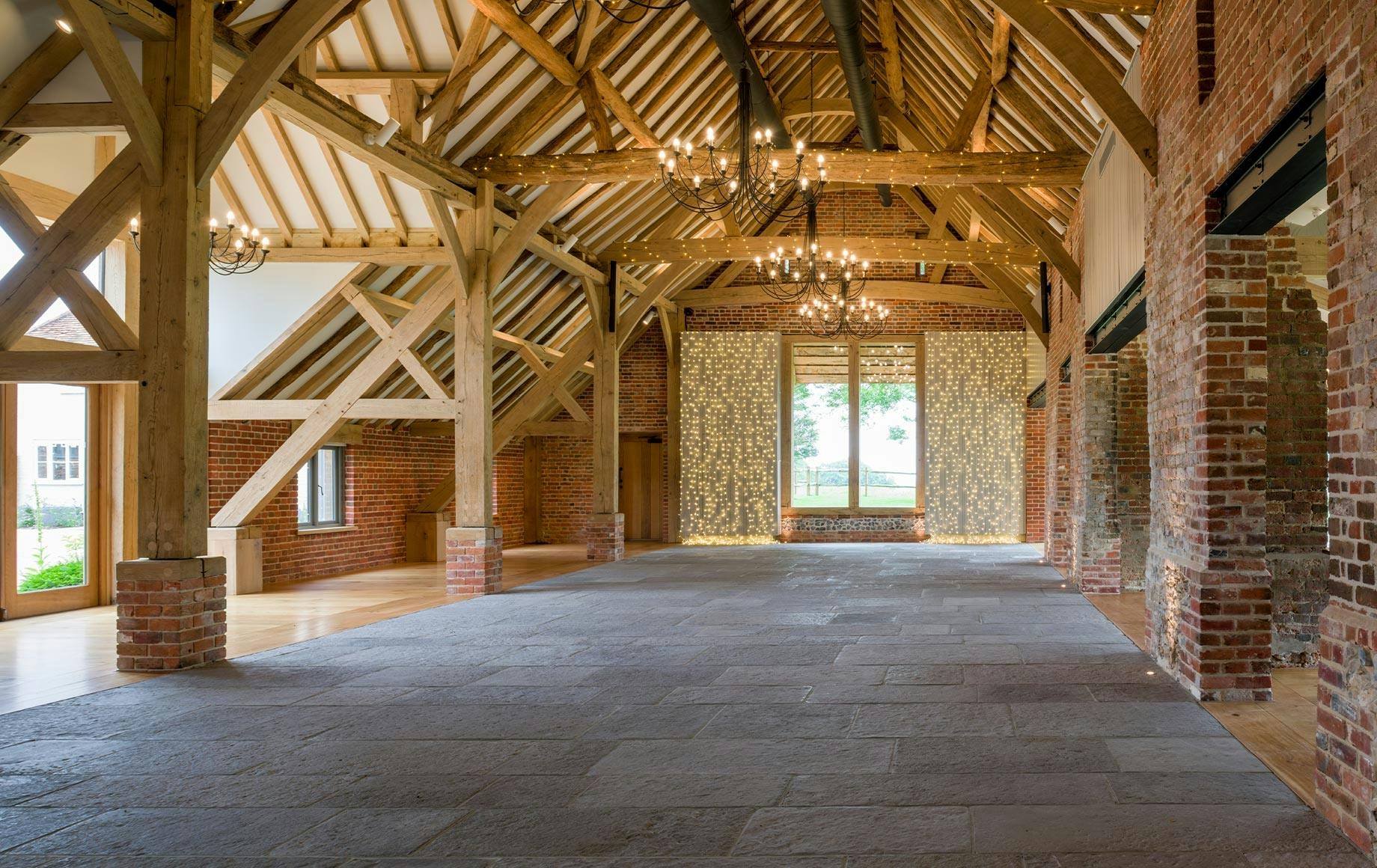 An oak framed wedding barn hall with a red brick wall