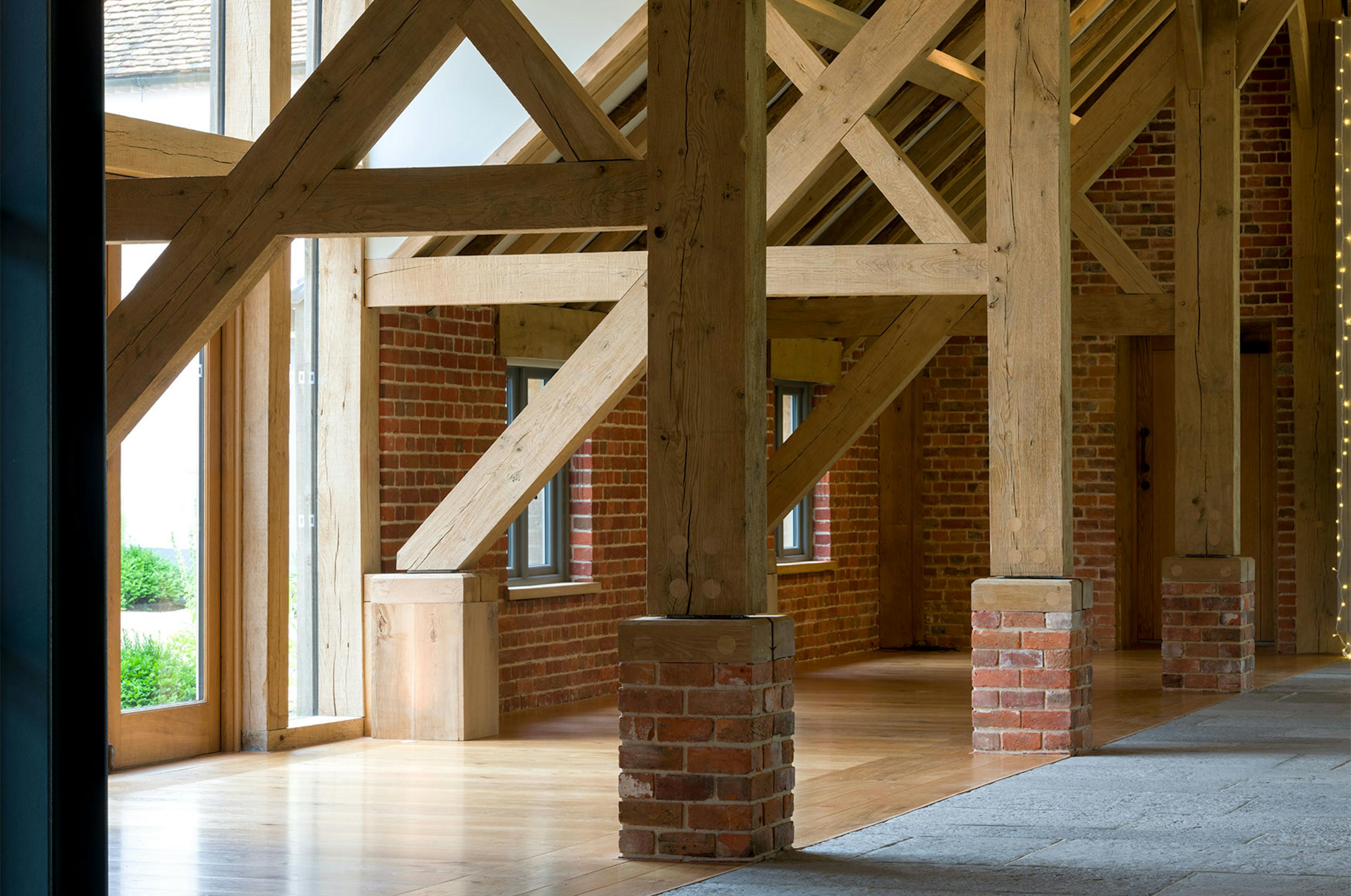 An oak framed wedding barn hall with oak posts on red brick post feet