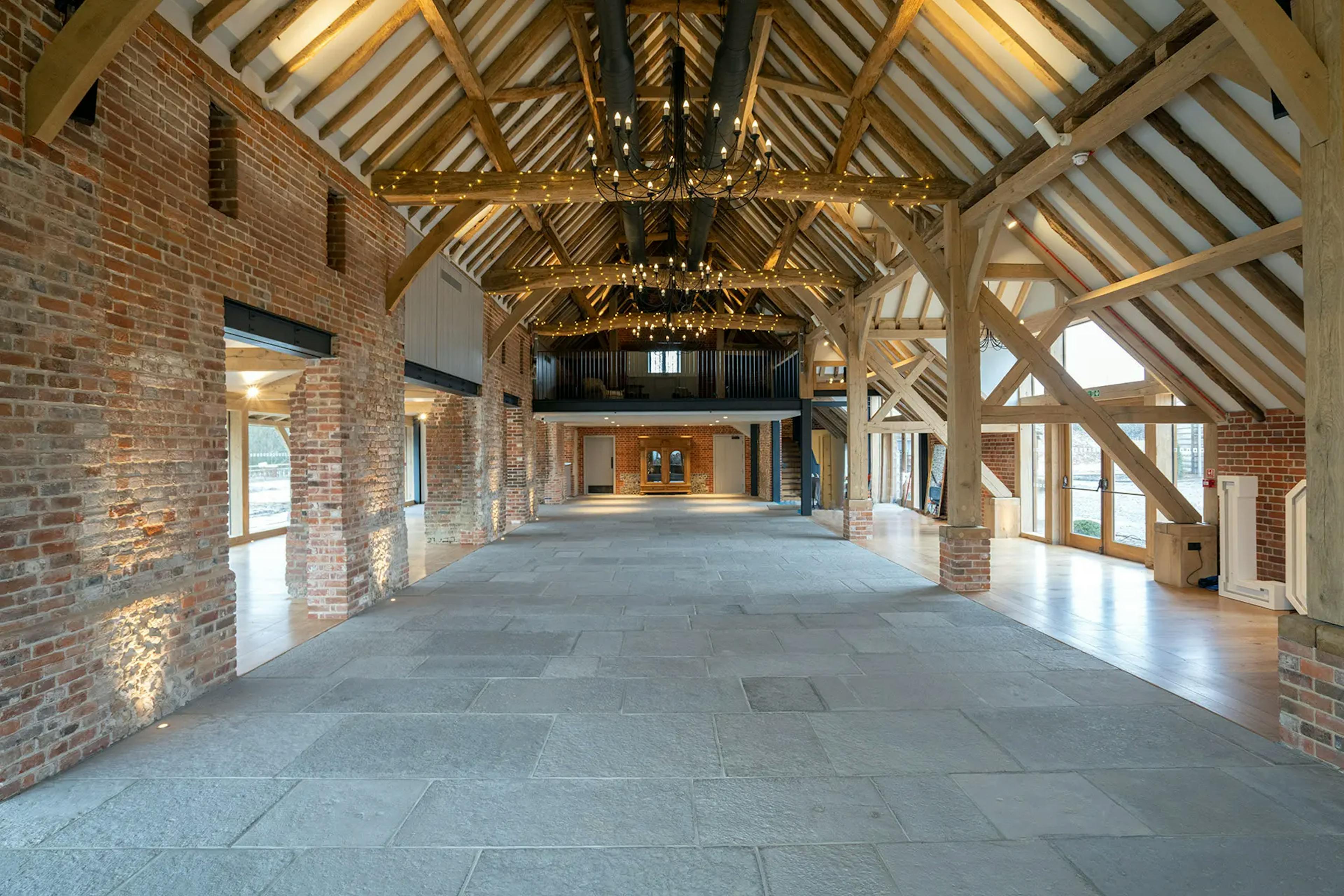 An oak framed wedding barn hall with a red brick wall