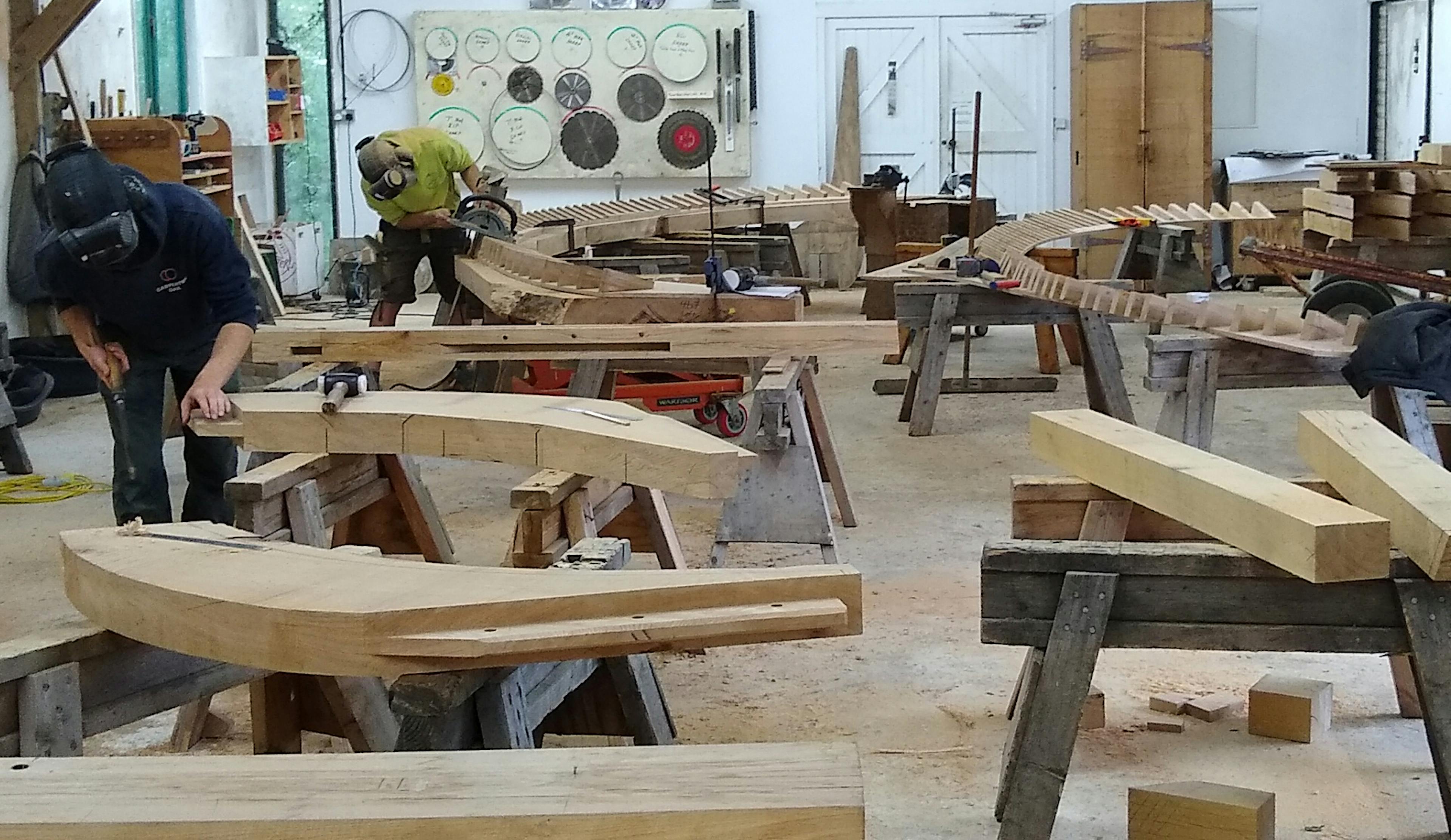 A complex octagonal oak roof structure during manufacture in a workshop