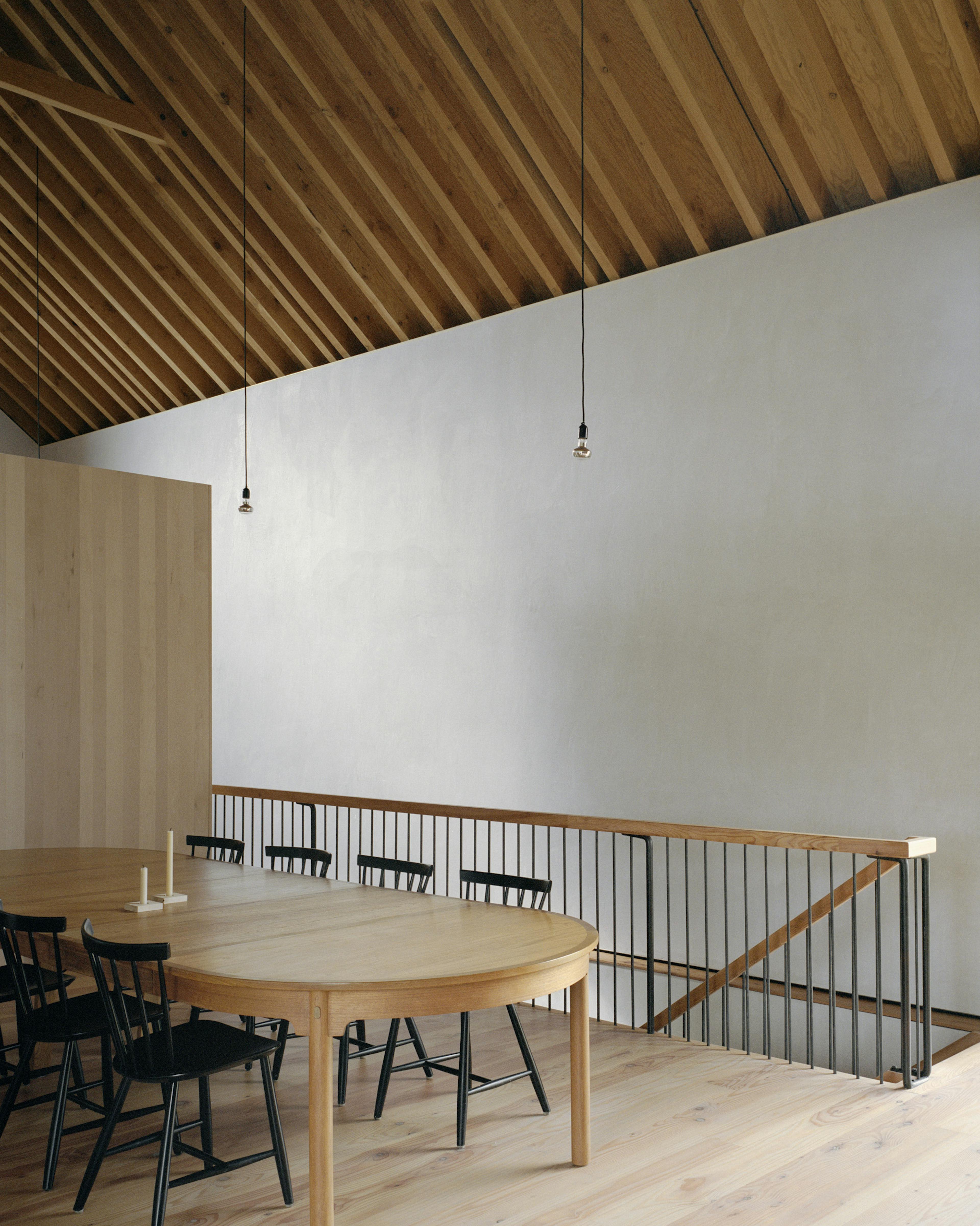 The dining area of a renovated stone barn with a Douglas fir framed roof structure