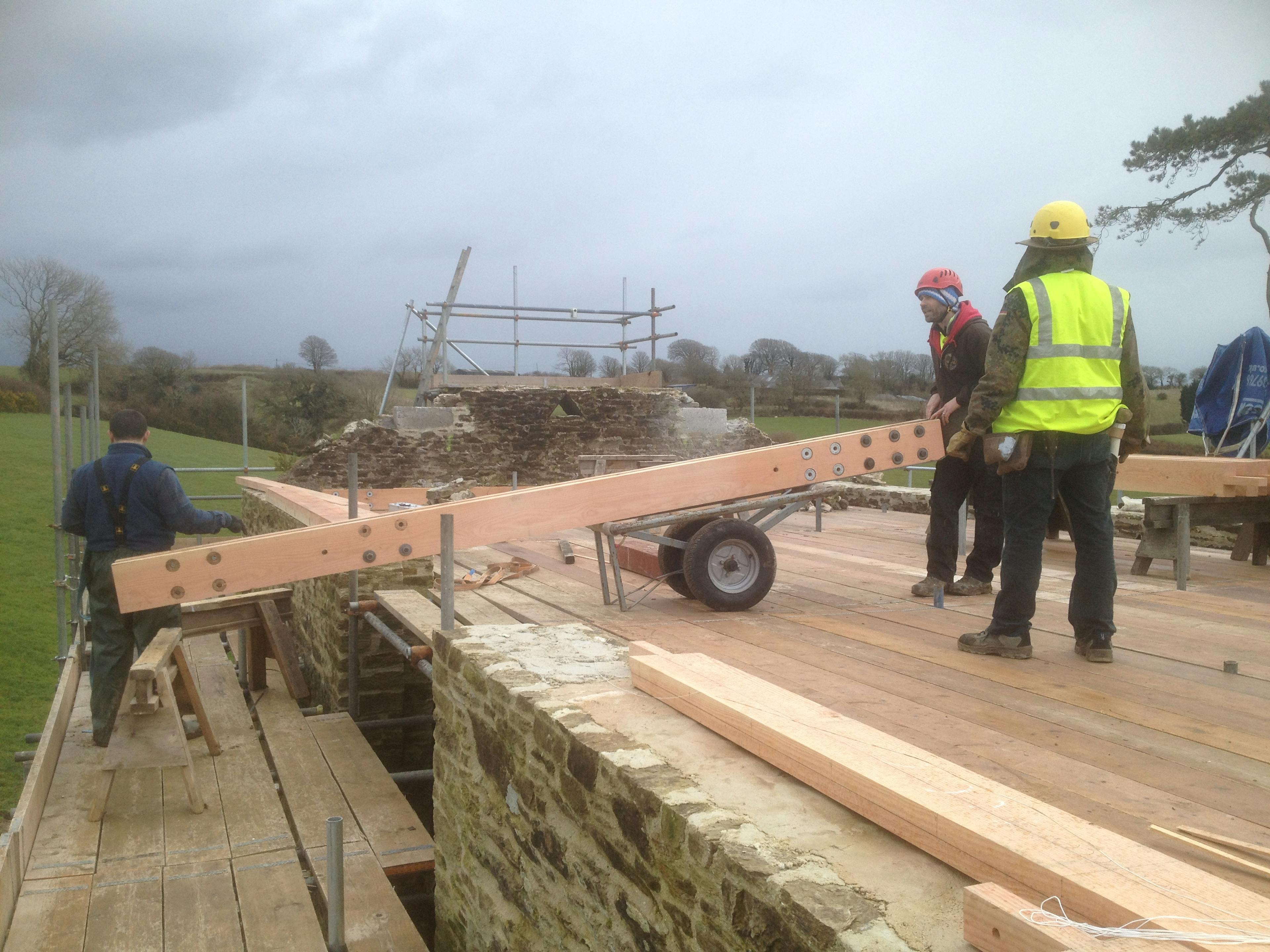 A Douglas fir frame with steel connections being put into place by carpenters during renovation of a barn