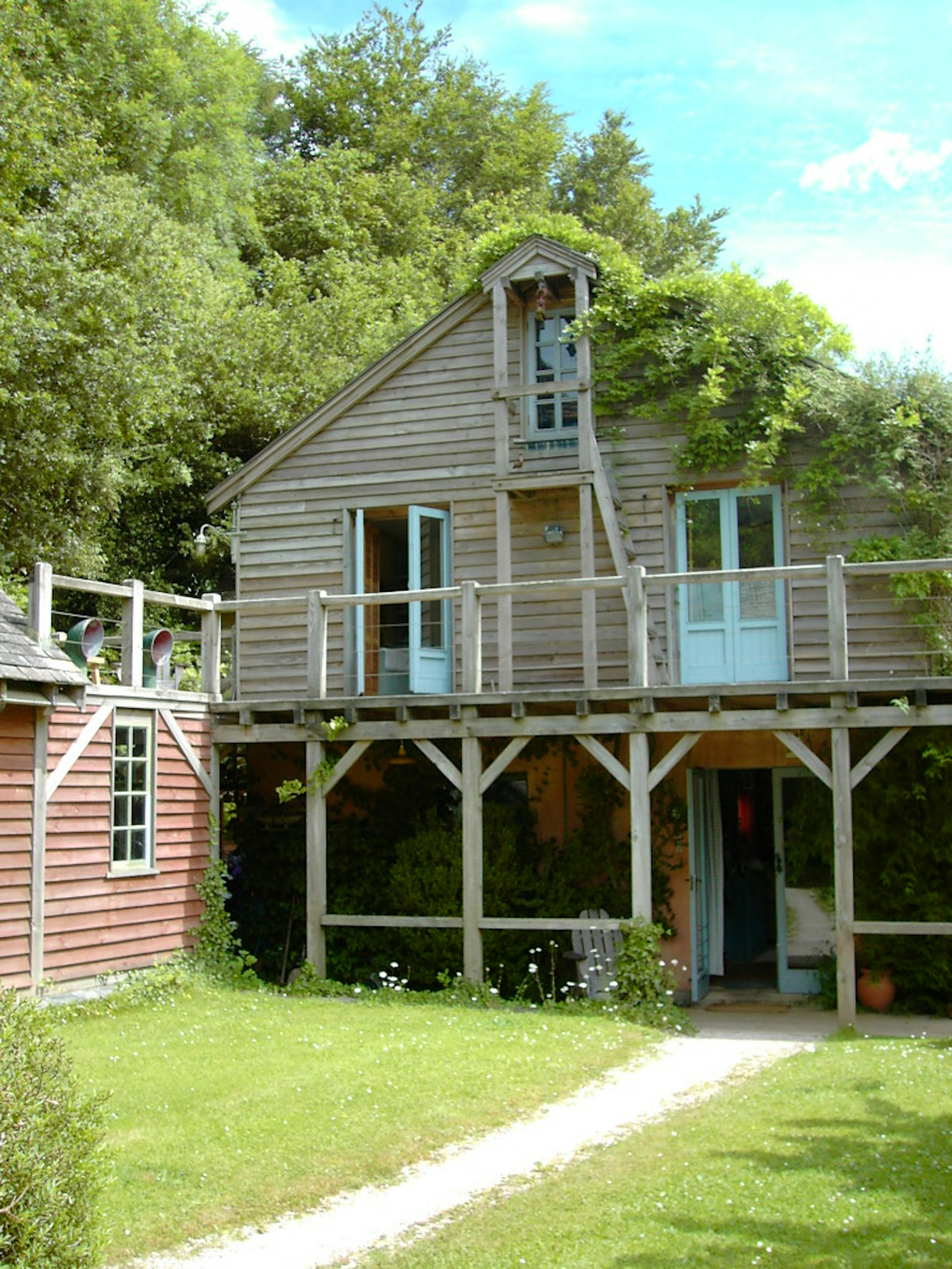 A timber clad oak framed home with an oak balcony set in a pretty garden