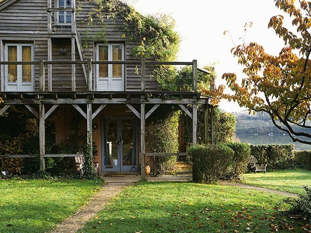 A timber clad oak framed home with an oak balcony set in a pretty garden