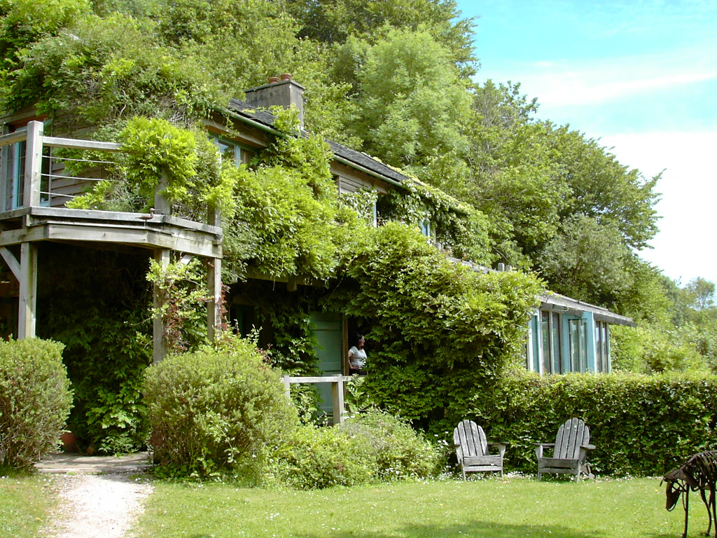 A timber clad oak framed home with an oak balcony set in a pretty garden