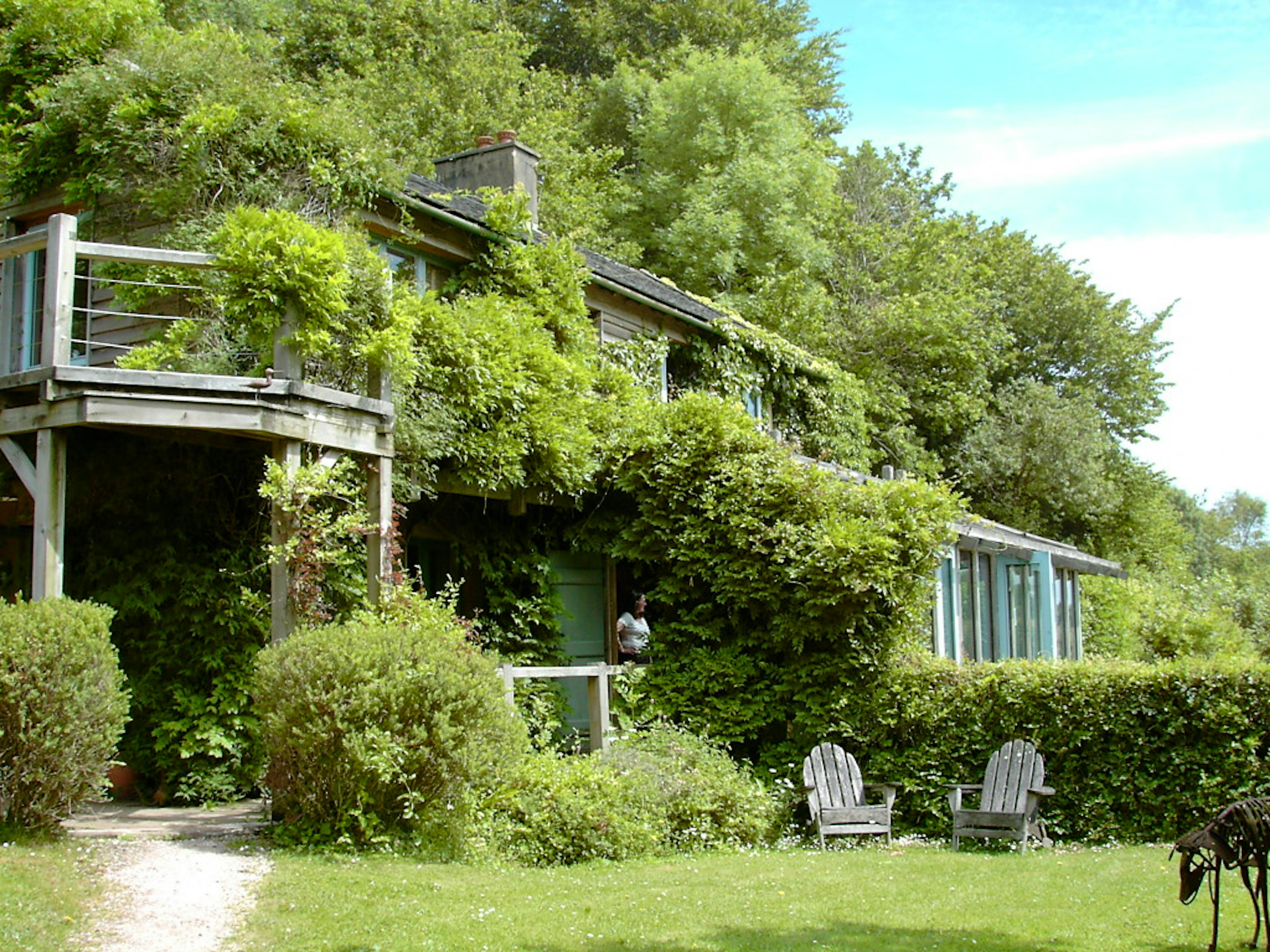 A timber clad oak framed home with an oak balcony set in a pretty garden