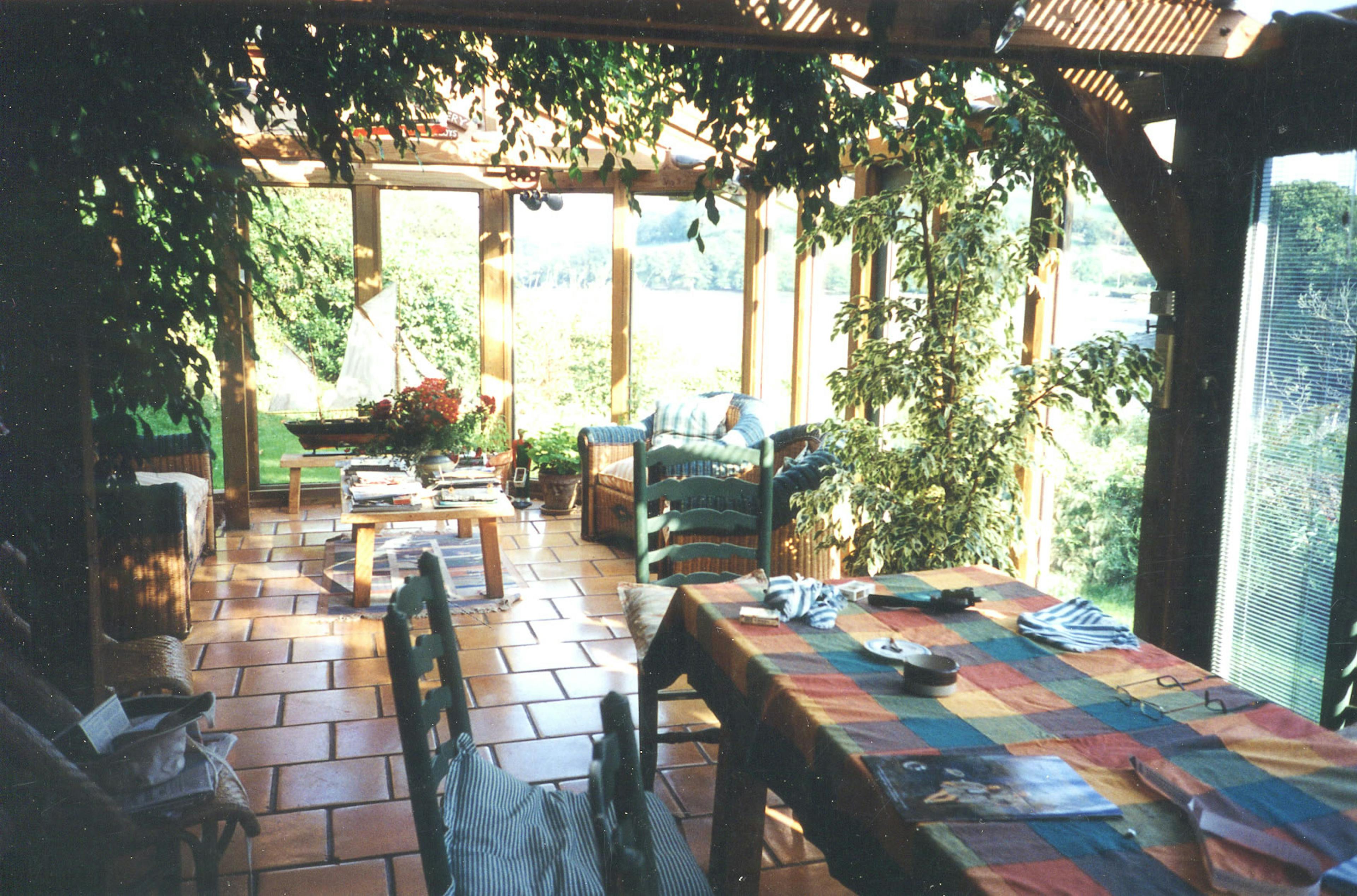 An oak framed orangery conservatory garden room with seating and plants