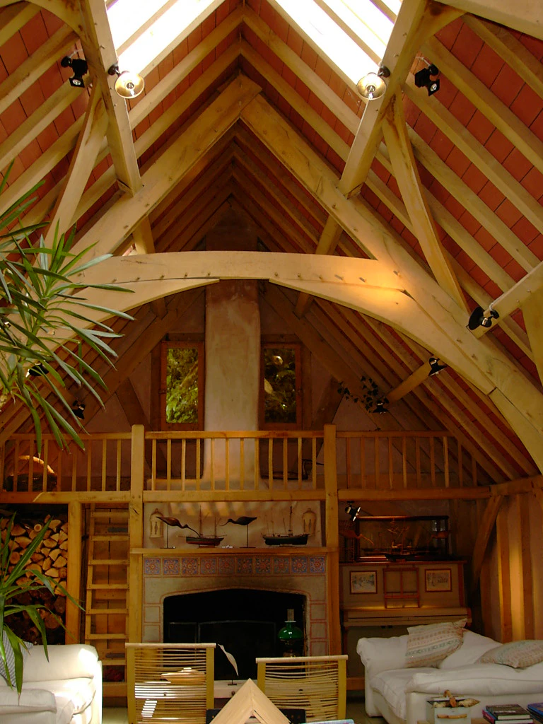 A sitting area with a fireplace in an oak framed home with a cruck truss