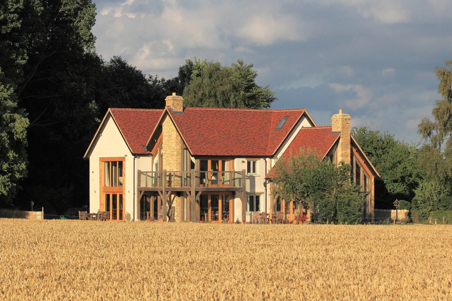 An oak framed home with red tiled roof and oak balconies