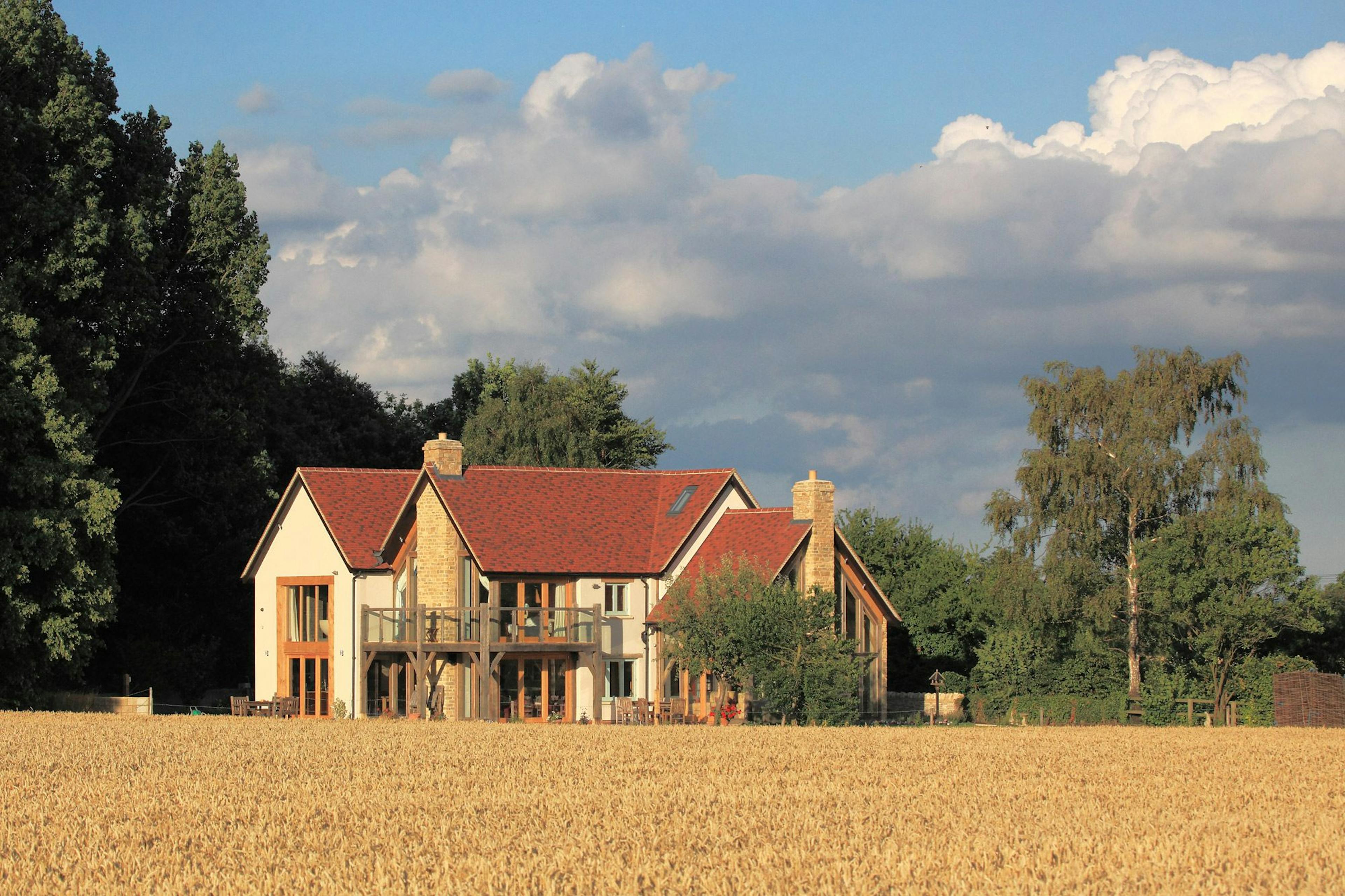 An oak framed home with red tiled roof and oak balconies