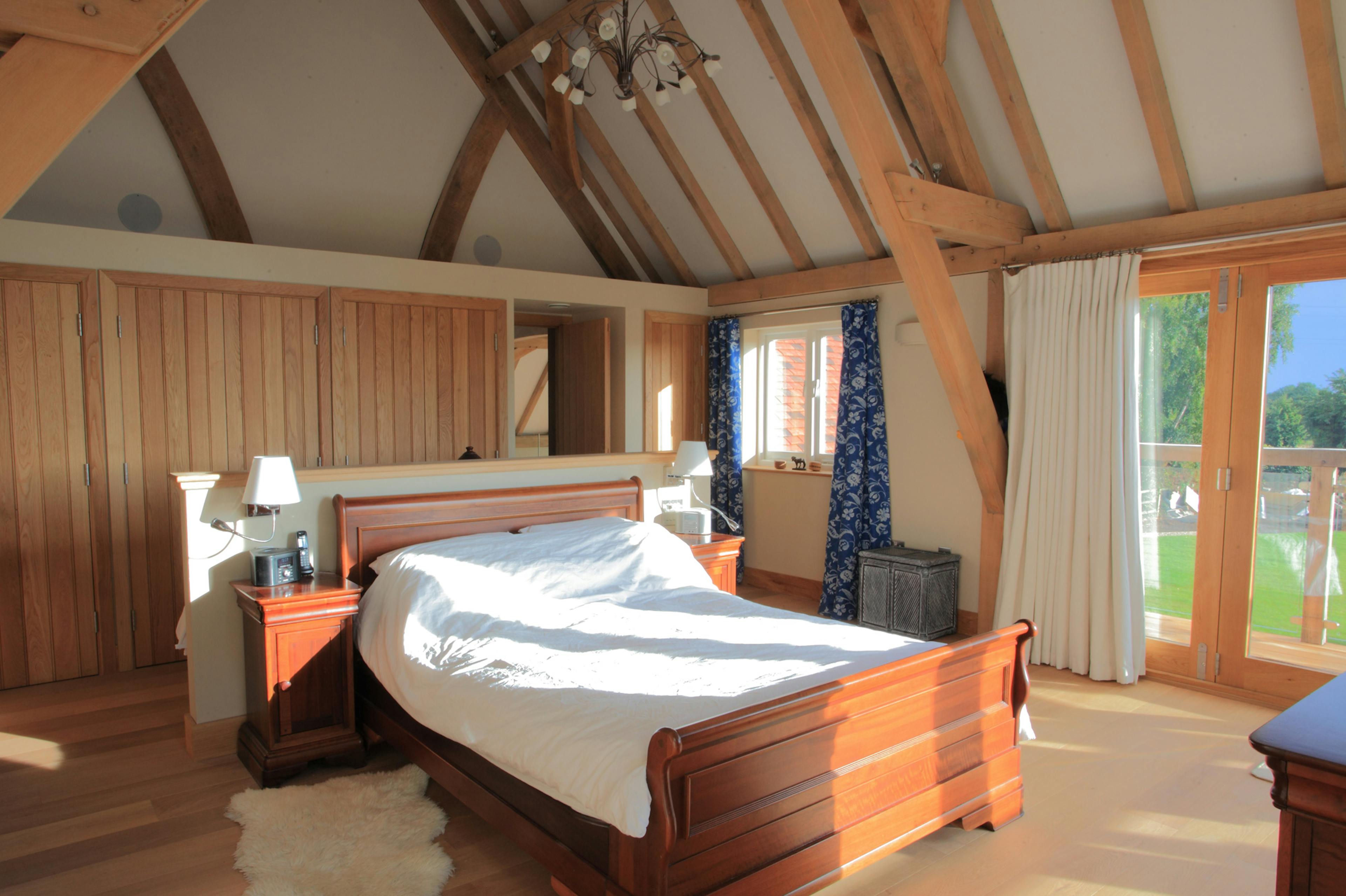 An oak framed bedroom with a vaulted ceiling