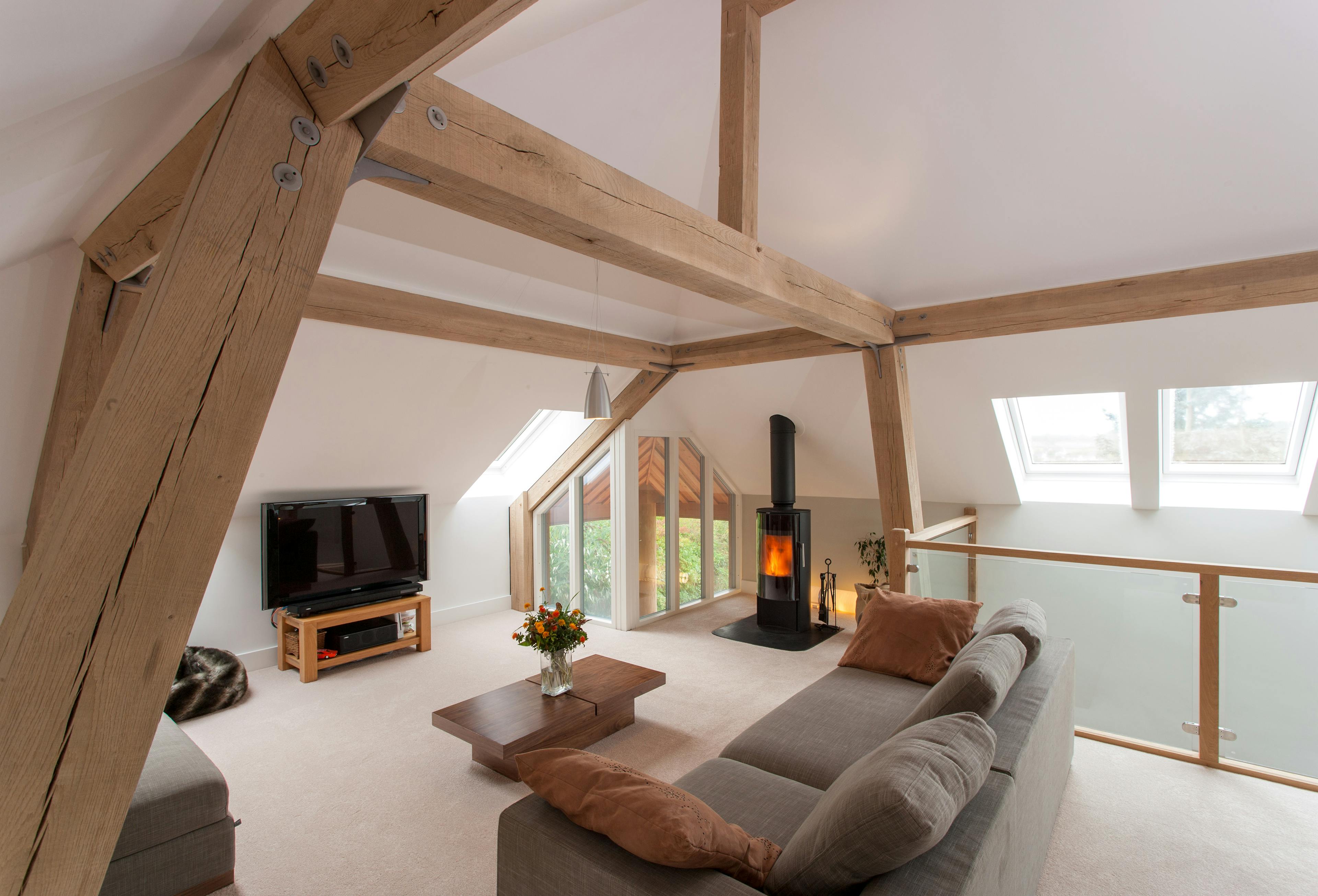 A sitting room with a log burner in a modern oak and steel framed home