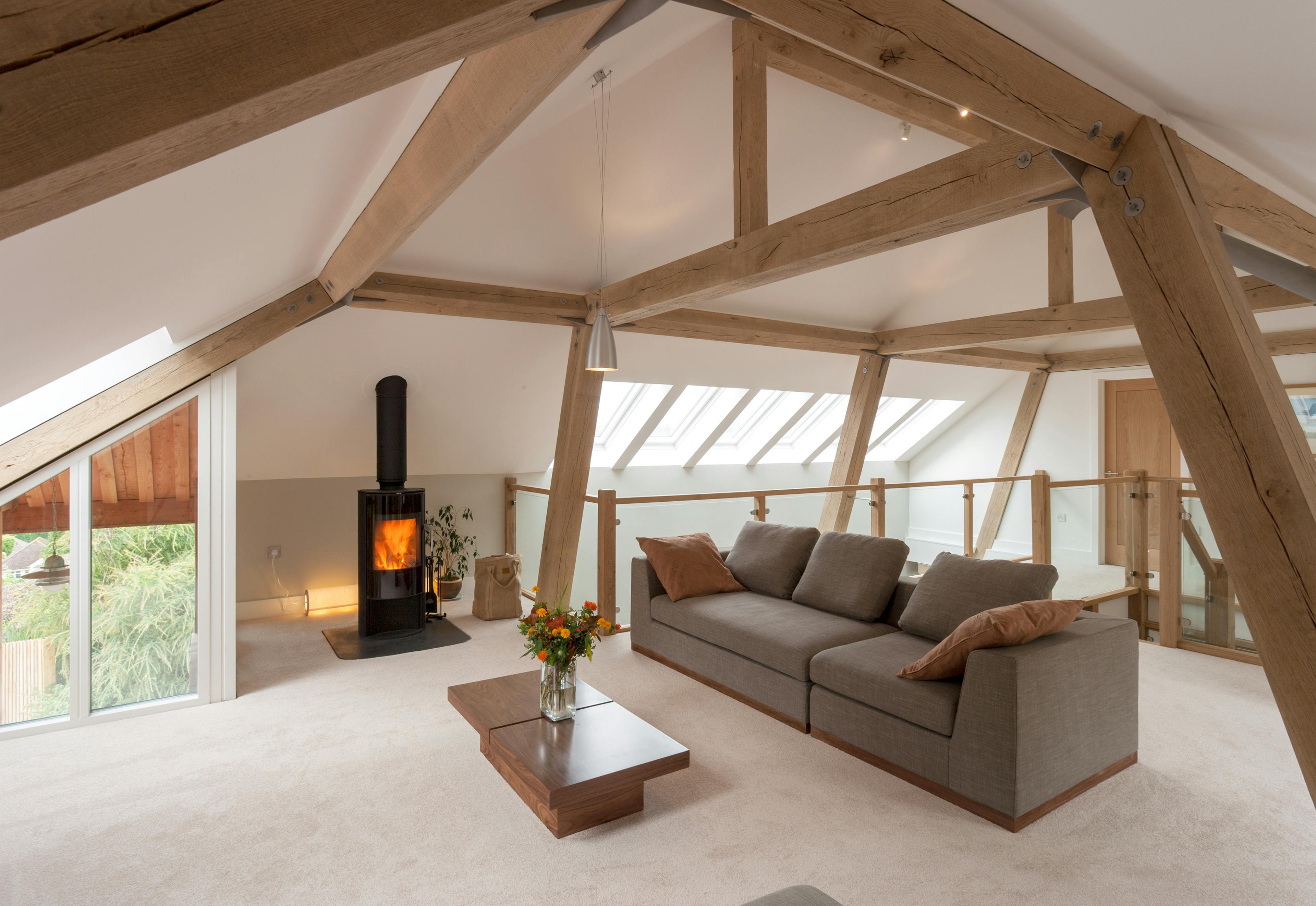A sitting room with a log burner in a modern oak and steel framed home
