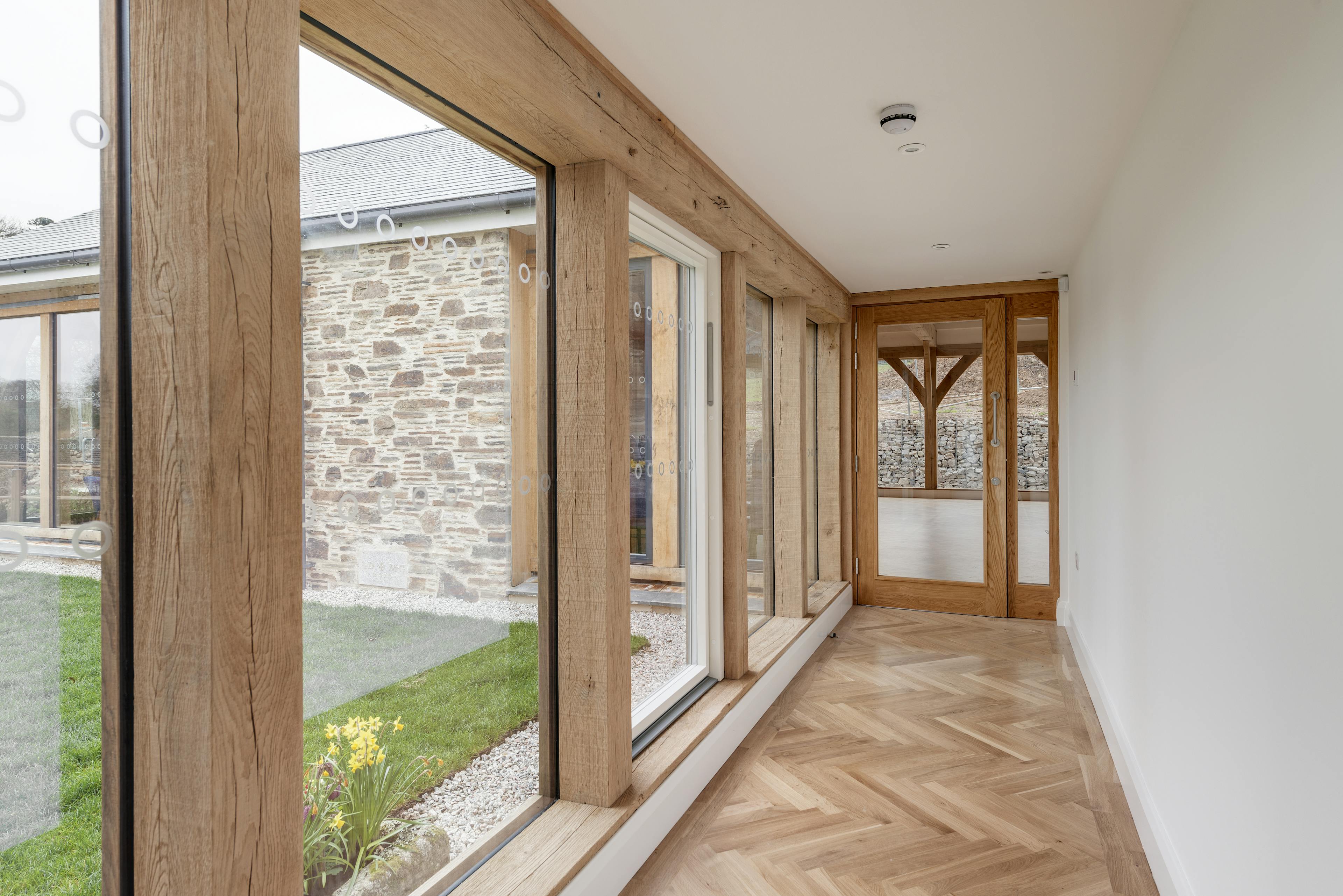 An oak framed corridor connecting an oak framed hall with a church