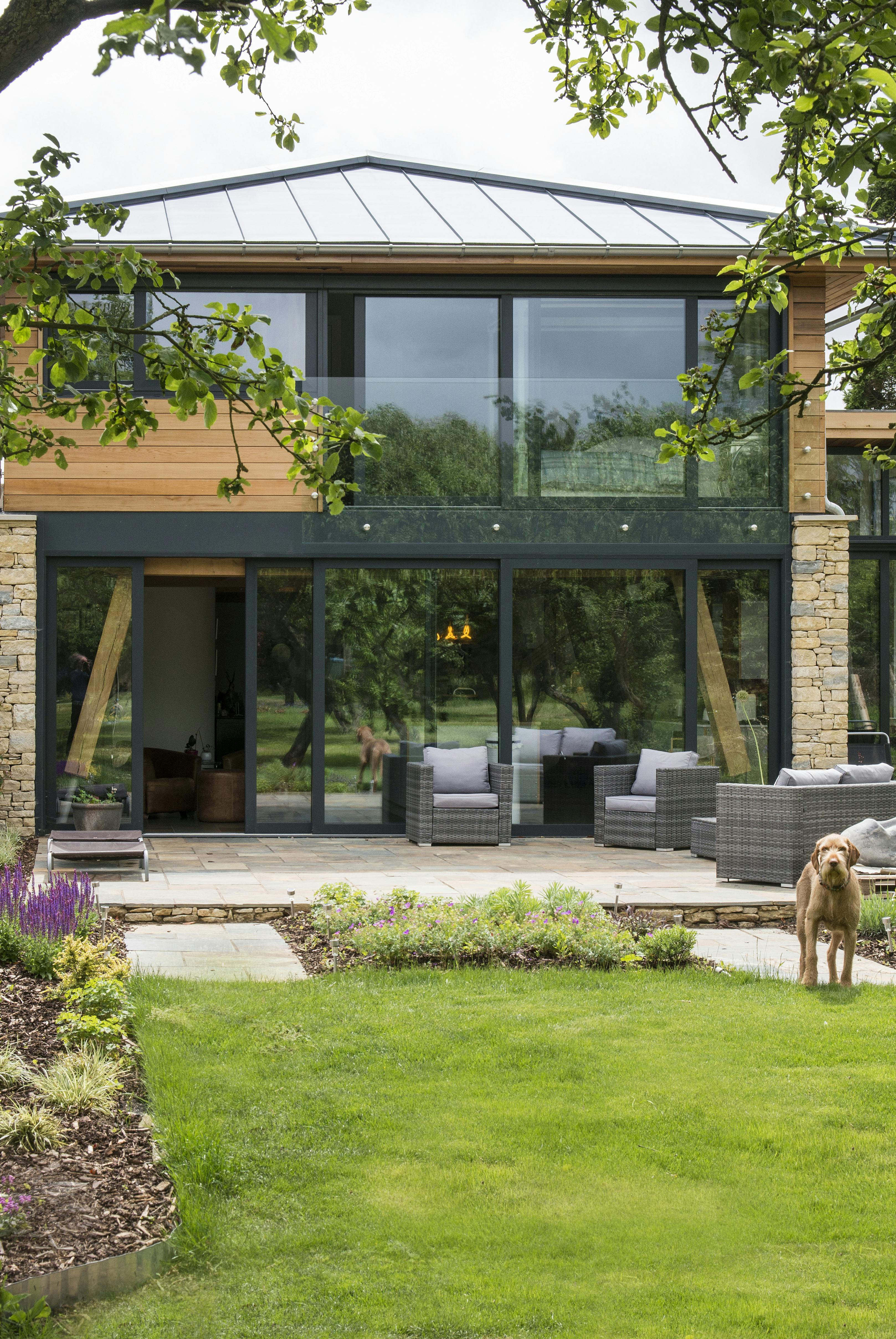 A modern two storey oak framed home with glazing, set in a landscaped garden