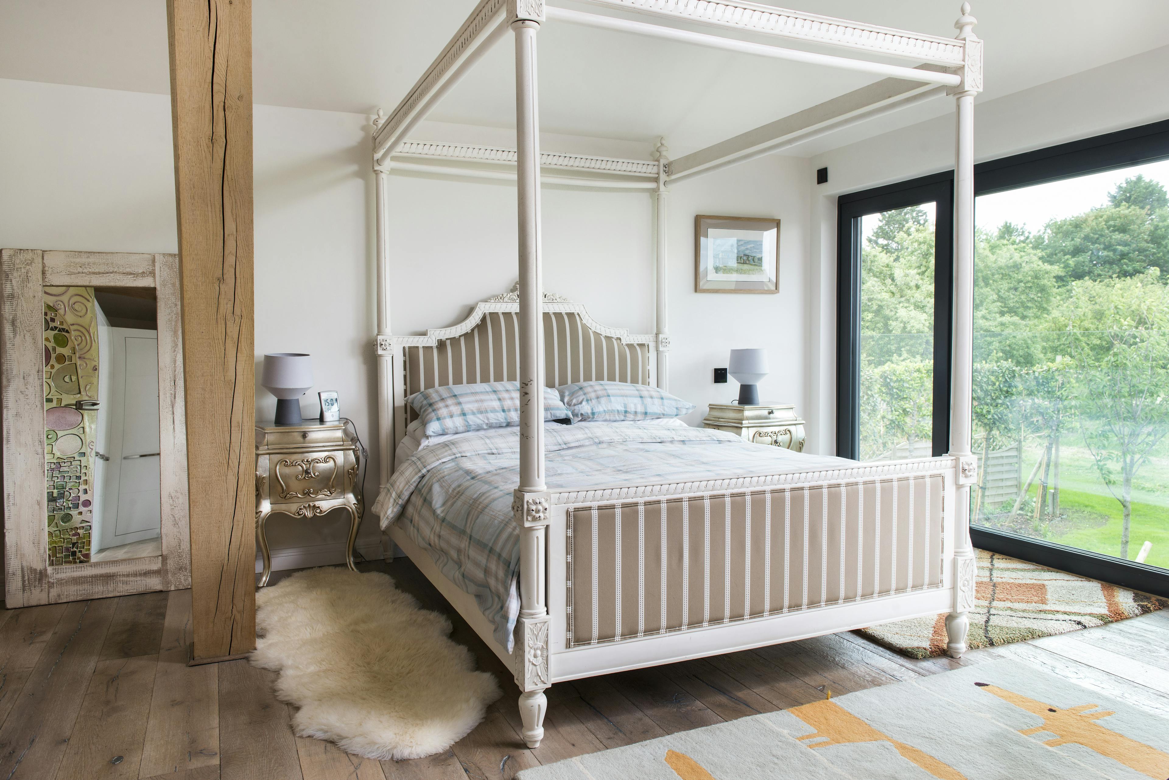 An oak framed bedroom with a white painted four poster bed