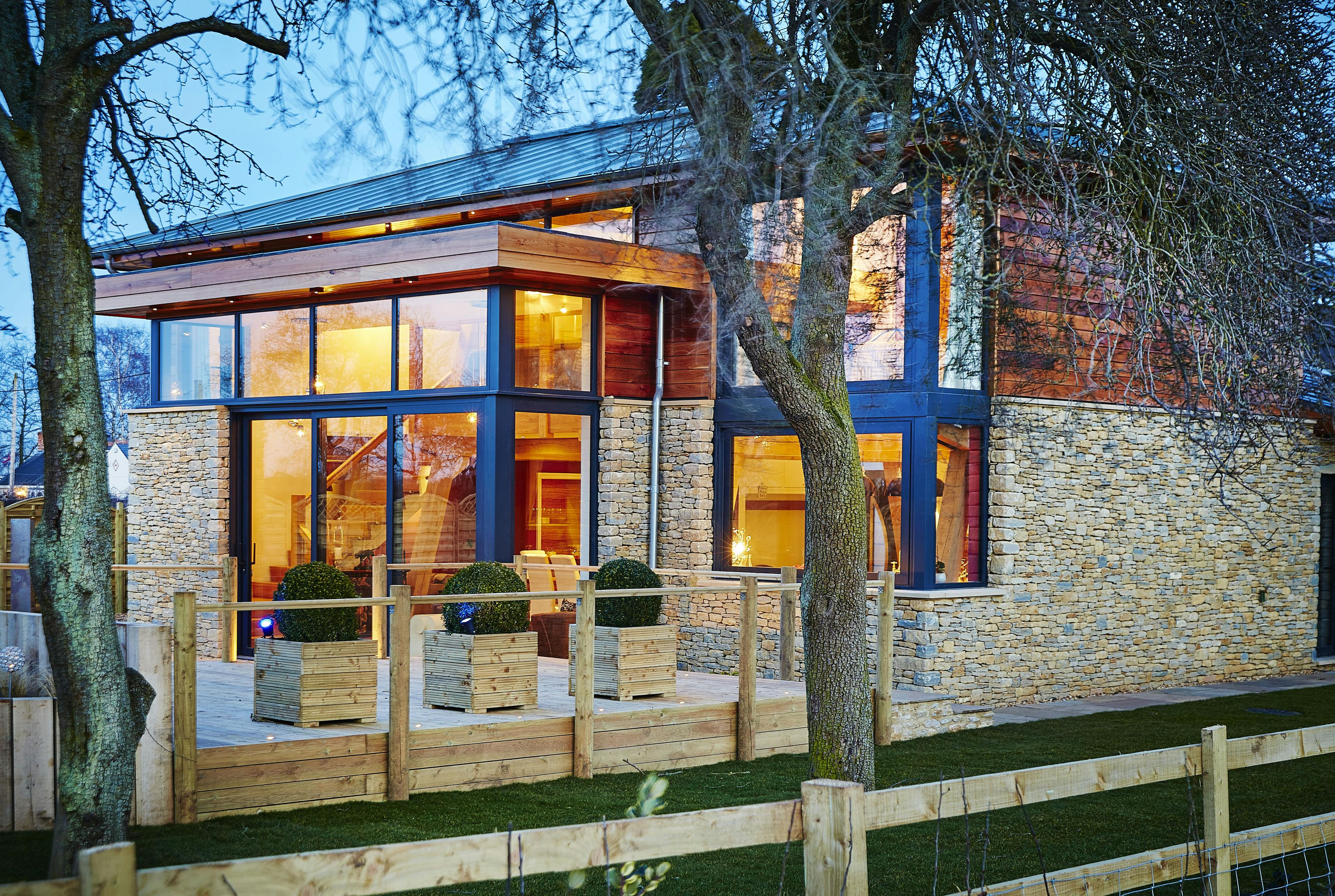 A modern two storey oak framed home with glazing, set in a landscaped garden