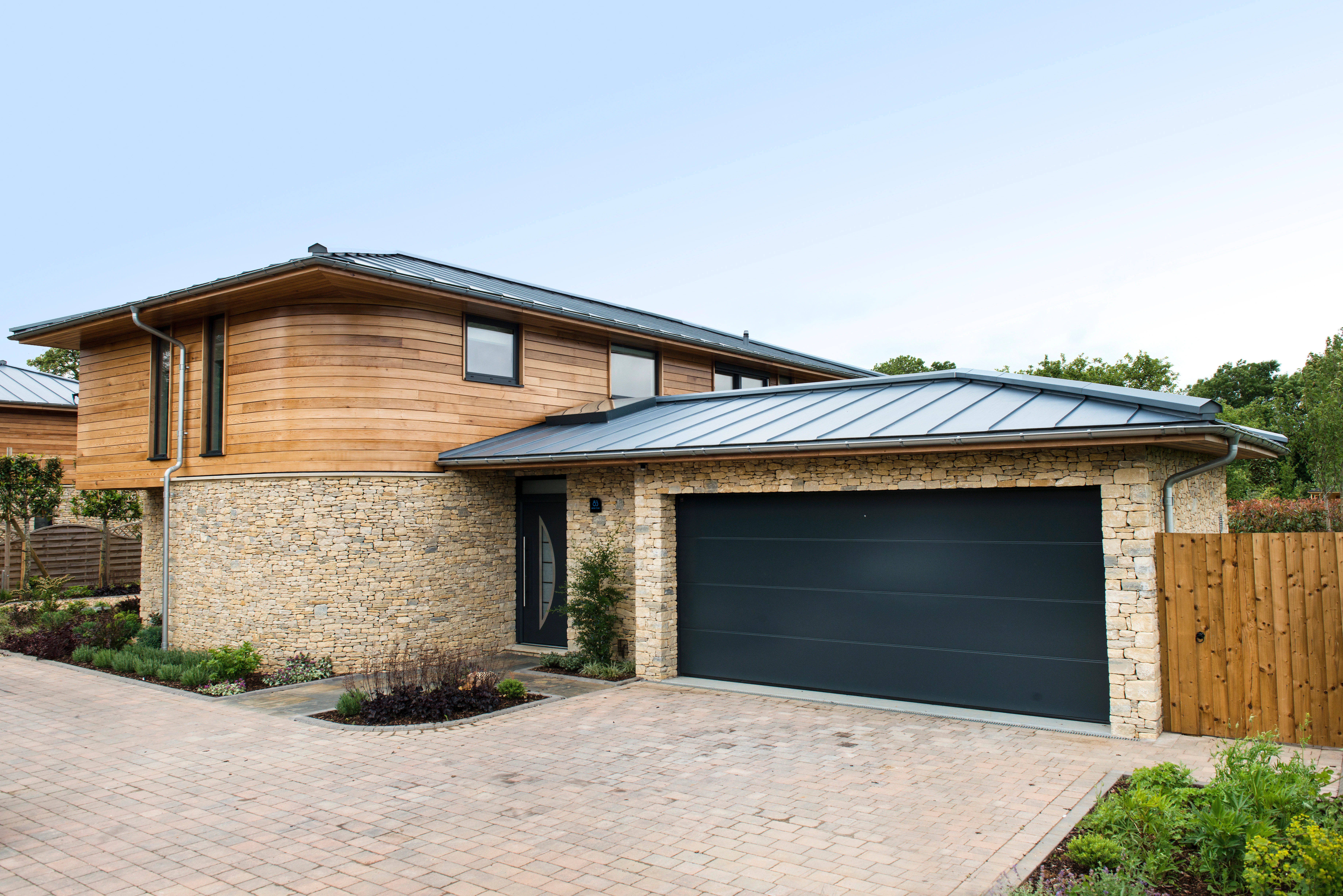 The rear of a modern two storey oak framed home with a garage