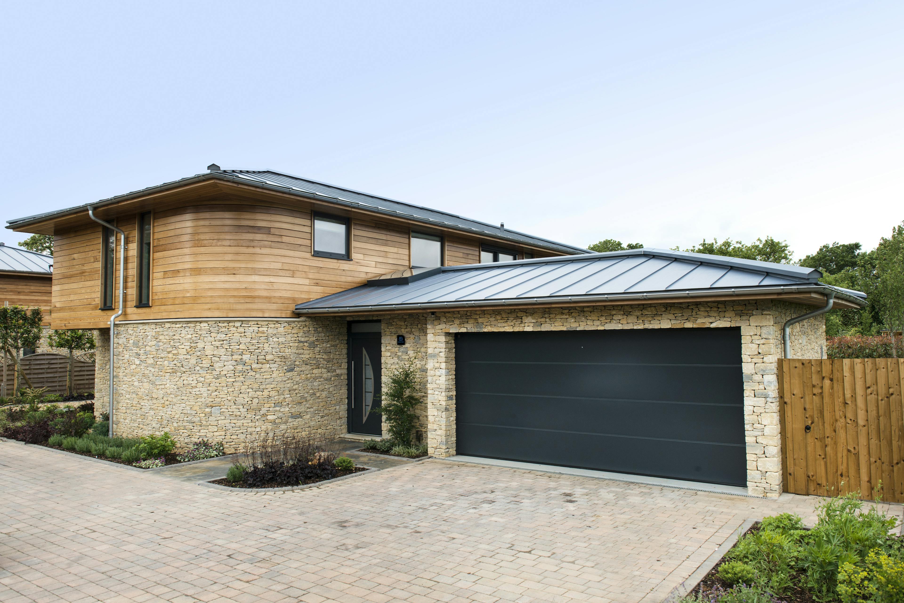 The rear of a modern two storey oak framed home with a garage